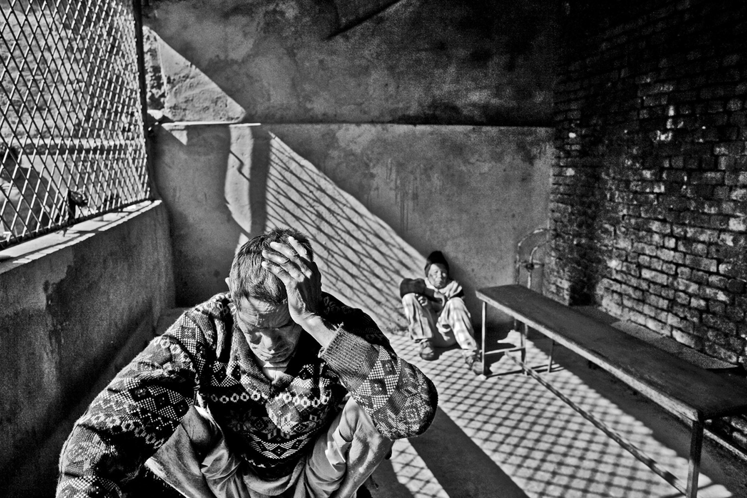 A male resident sits at a table in the dining hall of the home.