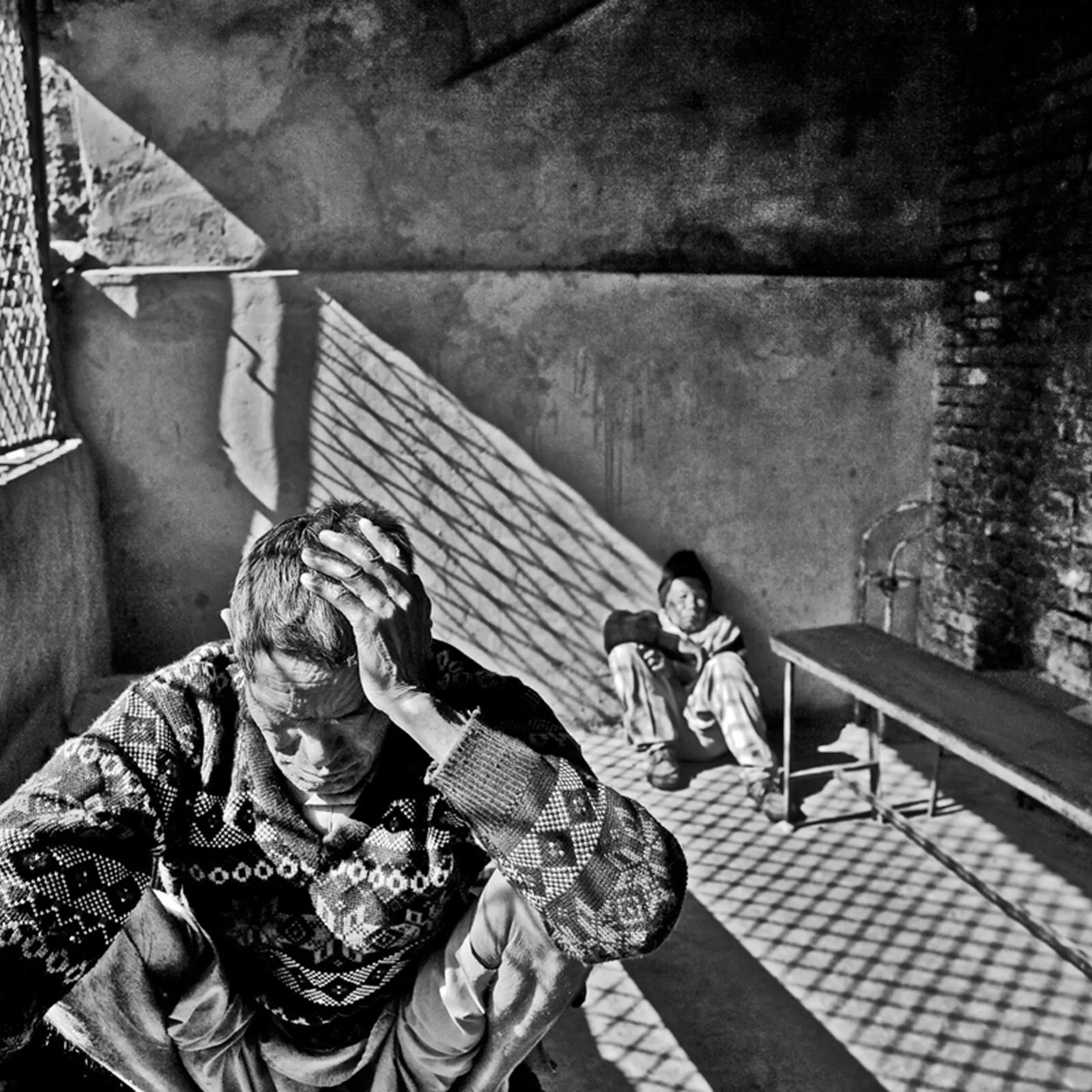 A male resident sits at a table in the dining hall of the home.