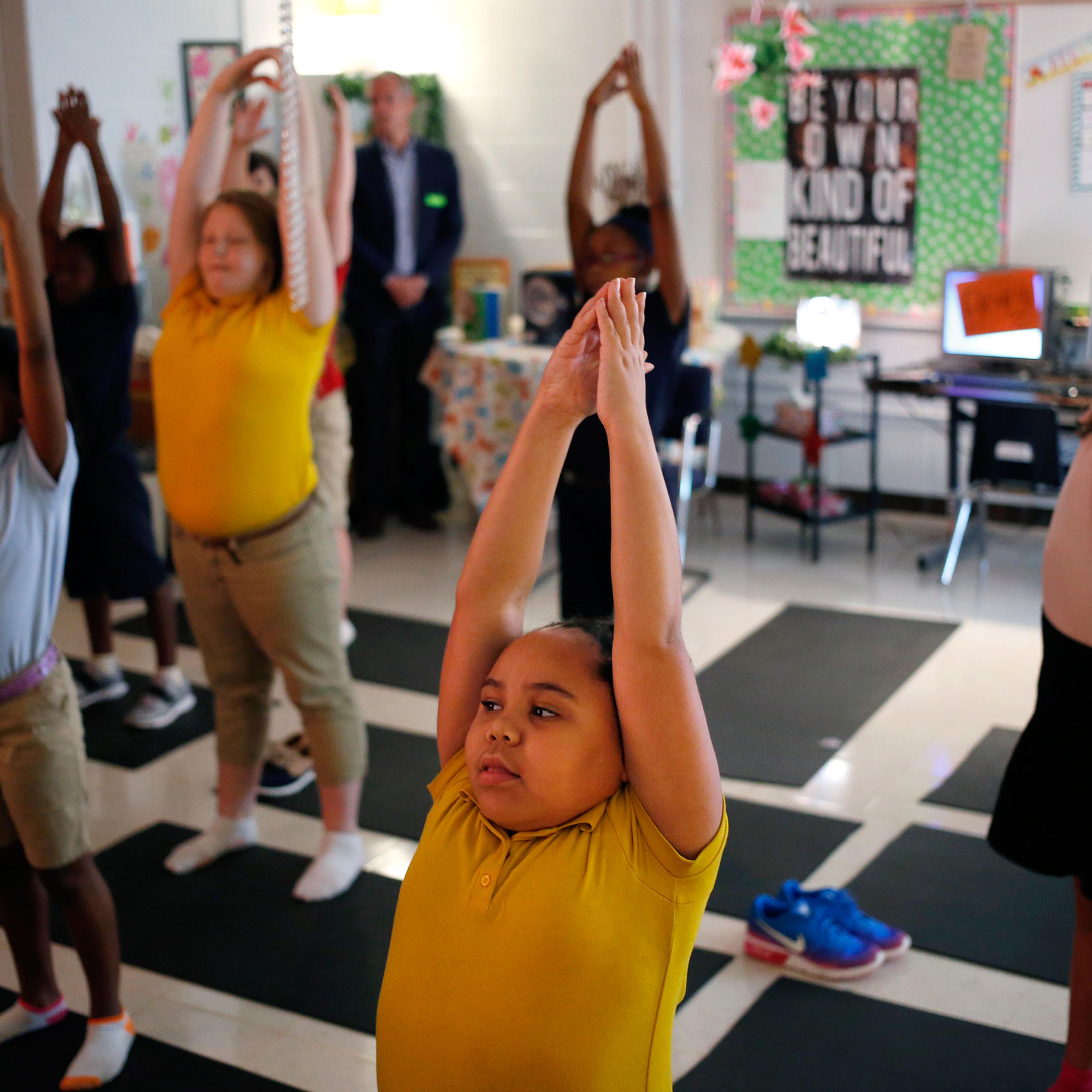 Fifth-graders flow through yoga-inspired poses in a mindfulness class at a public school in Louisville, Ky.