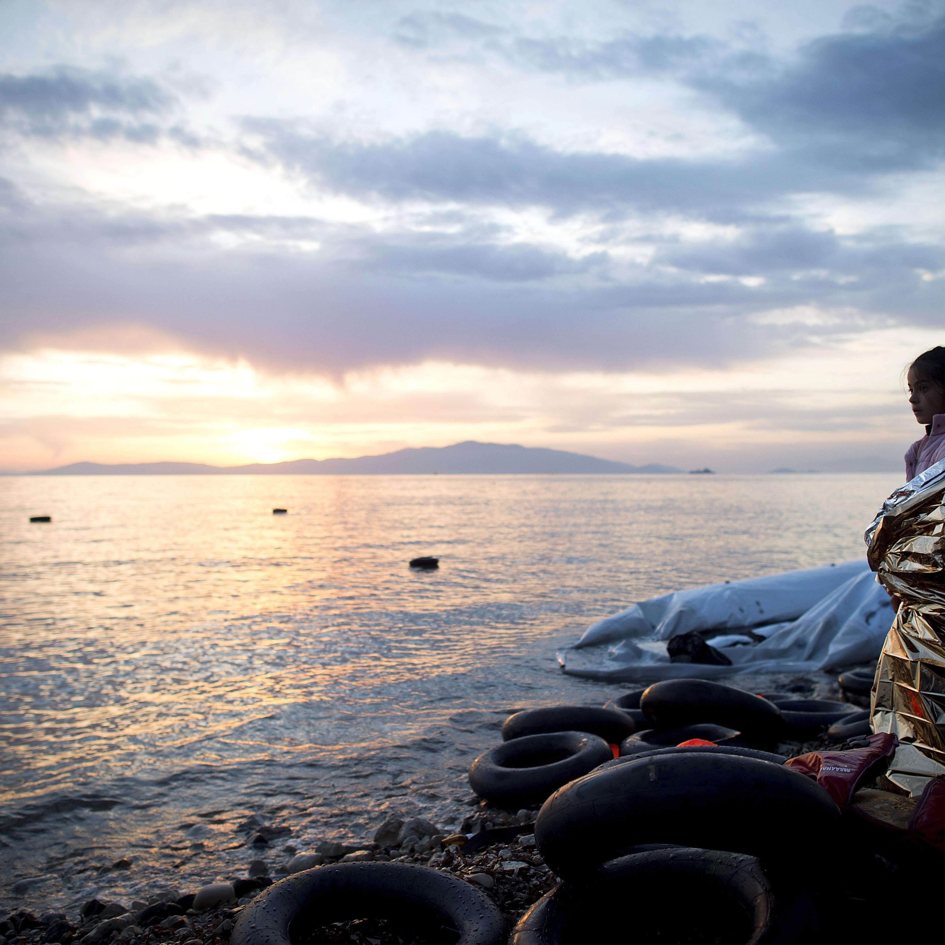 A Syrian girl looks on during sunrise after arriving on an inflatable boat with other refugees, crossing the sea from Turkey to Lesbos, some 5 kilometres south of the capital of the Island, Mytelene on March 9, 2016. Turkey has announced today to take ba
