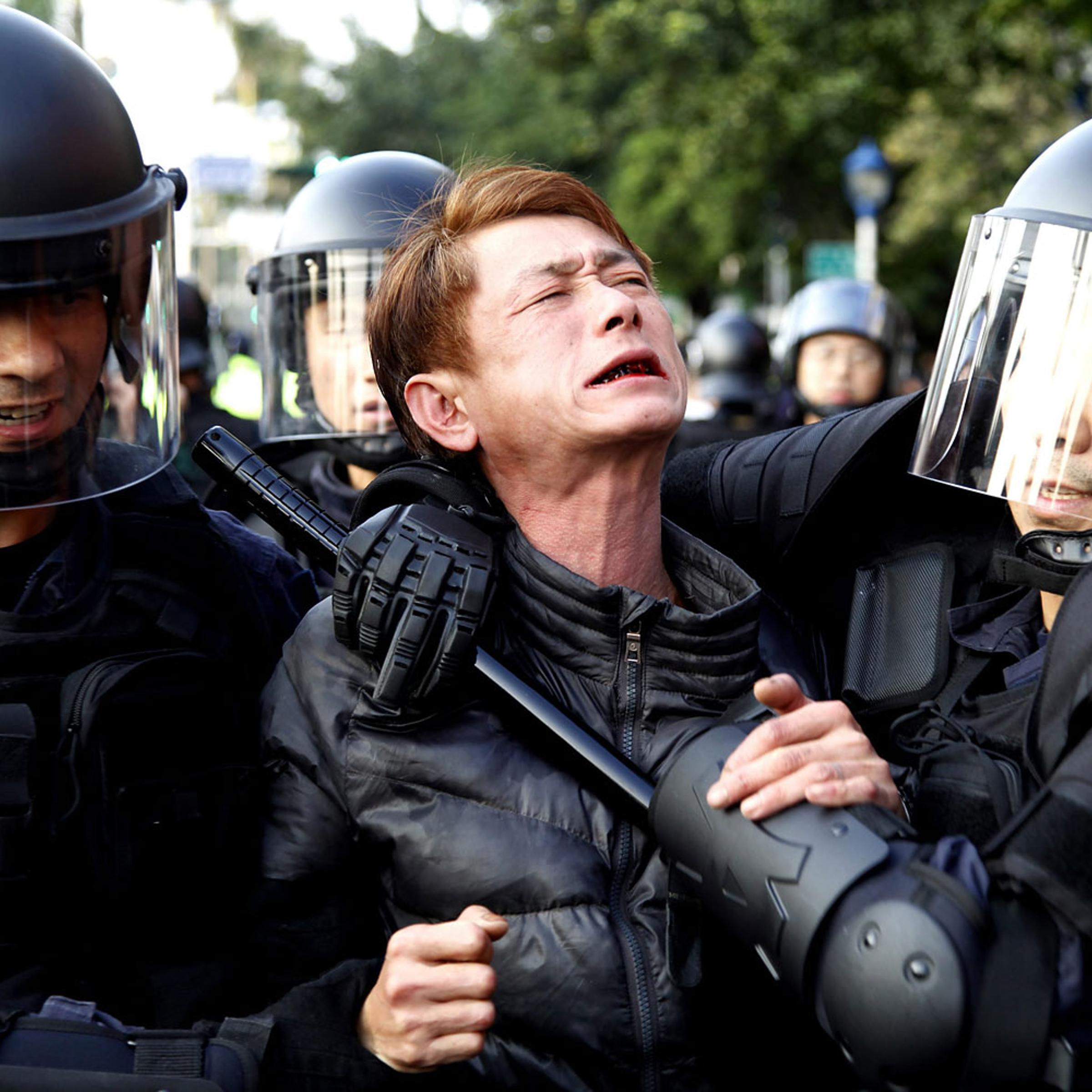 Riot police detain a protester near the Cabinet compound in Taipei, Taiwan, March 24, 2014.