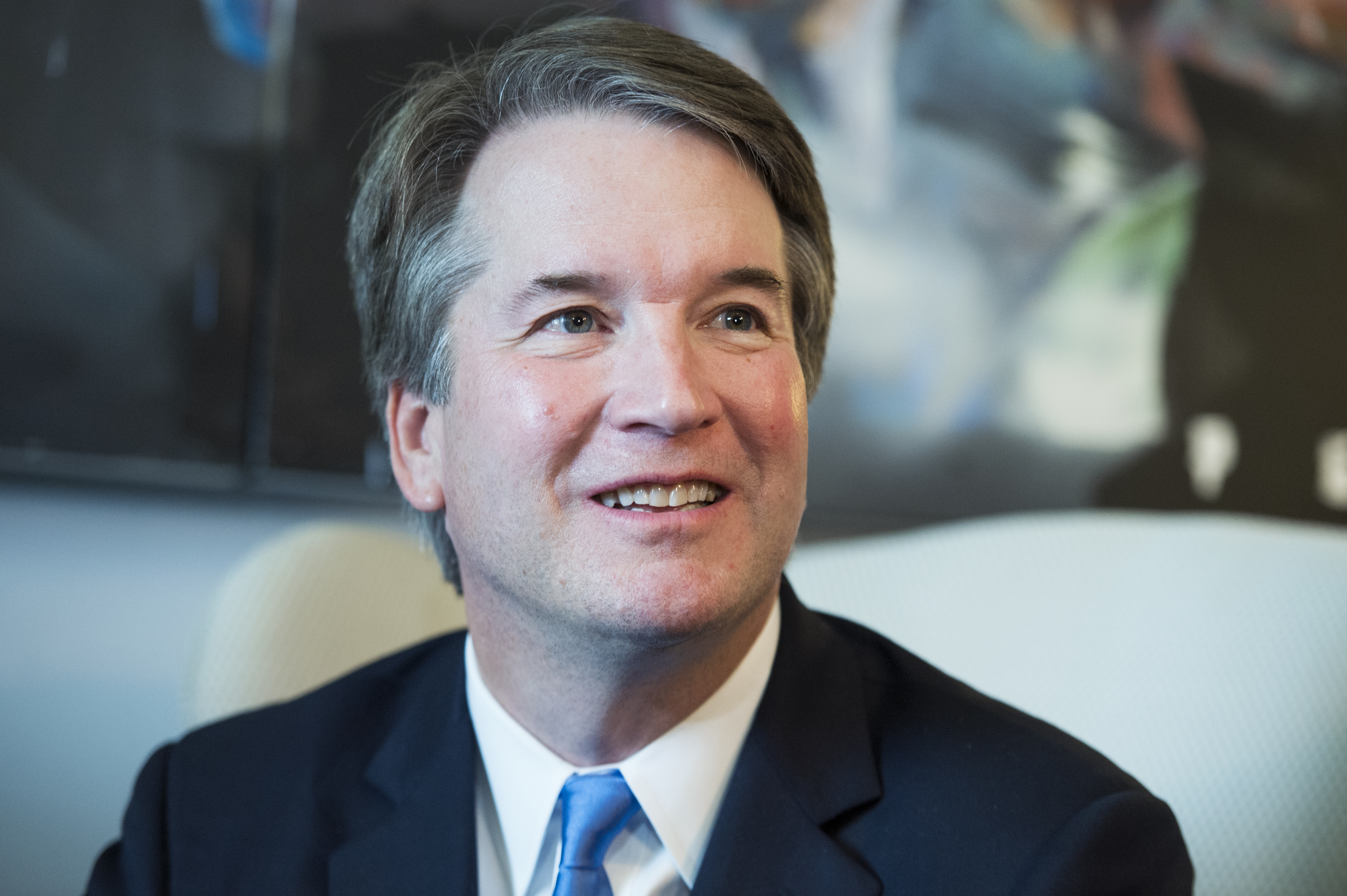 Brett Kavanaugh looks to the side of the camera with a light smile