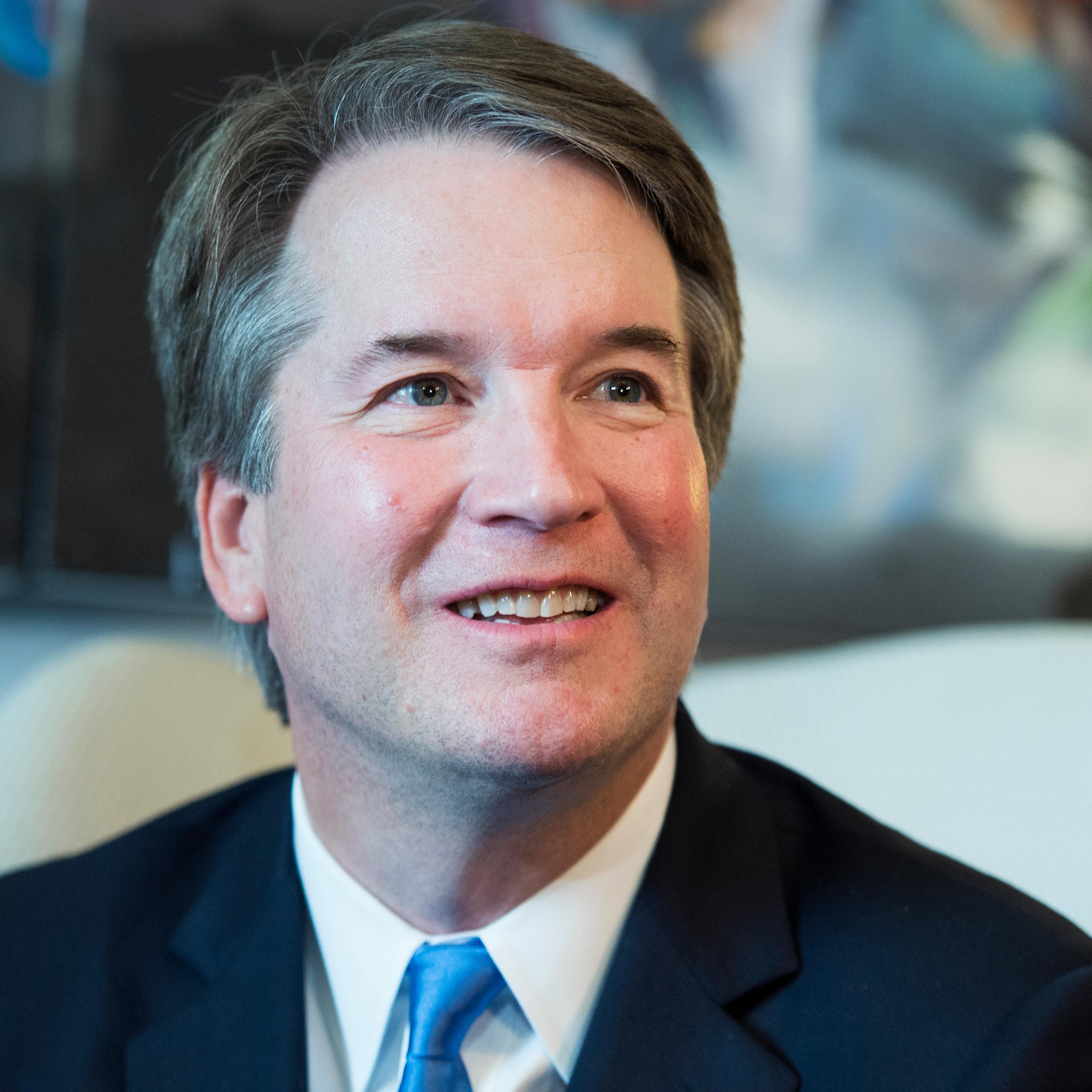 Brett Kavanaugh looks to the side of the camera with a light smile