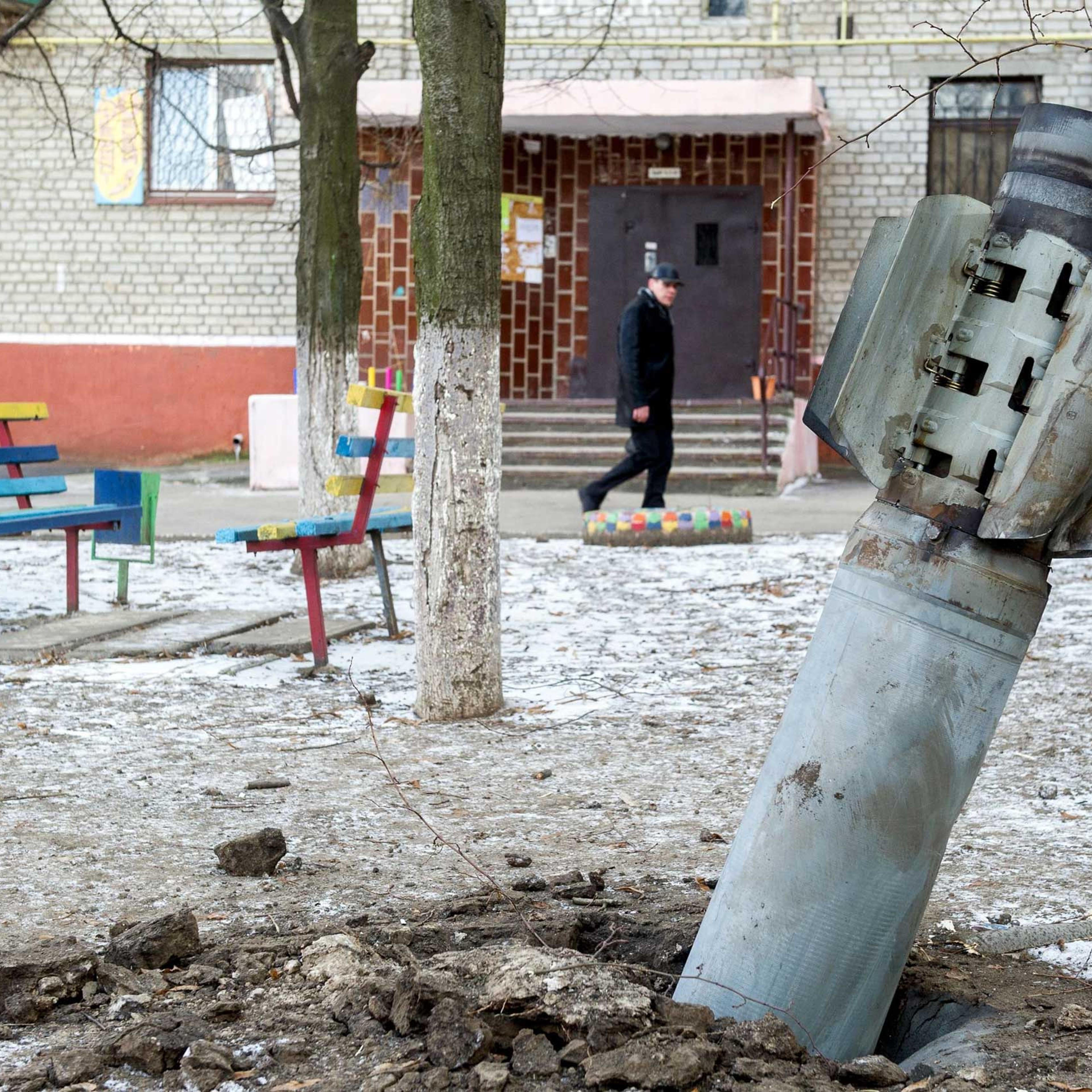 A man walks past an unexploded rocket in Kramatorsk, eastern Ukraine on Feb. 11, 2015.