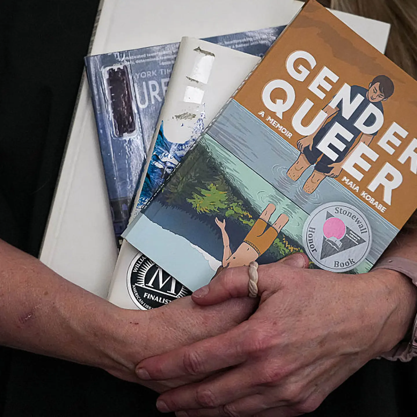 Suzette Baker, former head librarian at the Kingsland Branch Library in the Llano County Library System, holds some banned books at the Edwards Law office on Monday, Mar. 4, 2024 in Austin.