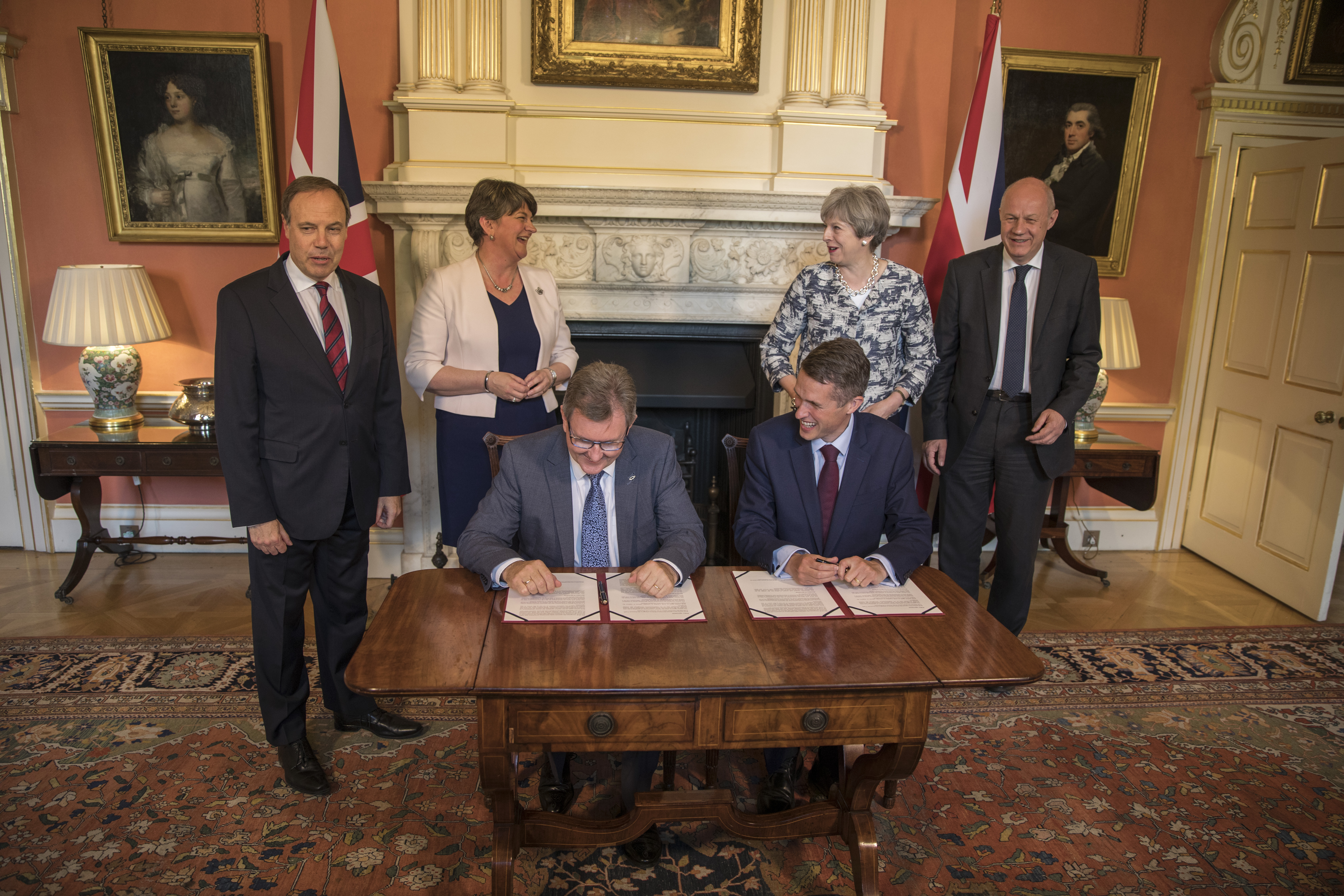 Prime Minister Theresa May (2R) stands with First Secretary of State Damian Green (R), Democratic Unionist Party (DUP) leader Arlene Foster (2L), DUP Deputy Leader Nigel Dodds (L) while DUP MP Jeffrey Donaldson (3L) and Parliamentary Secretary to the Tre