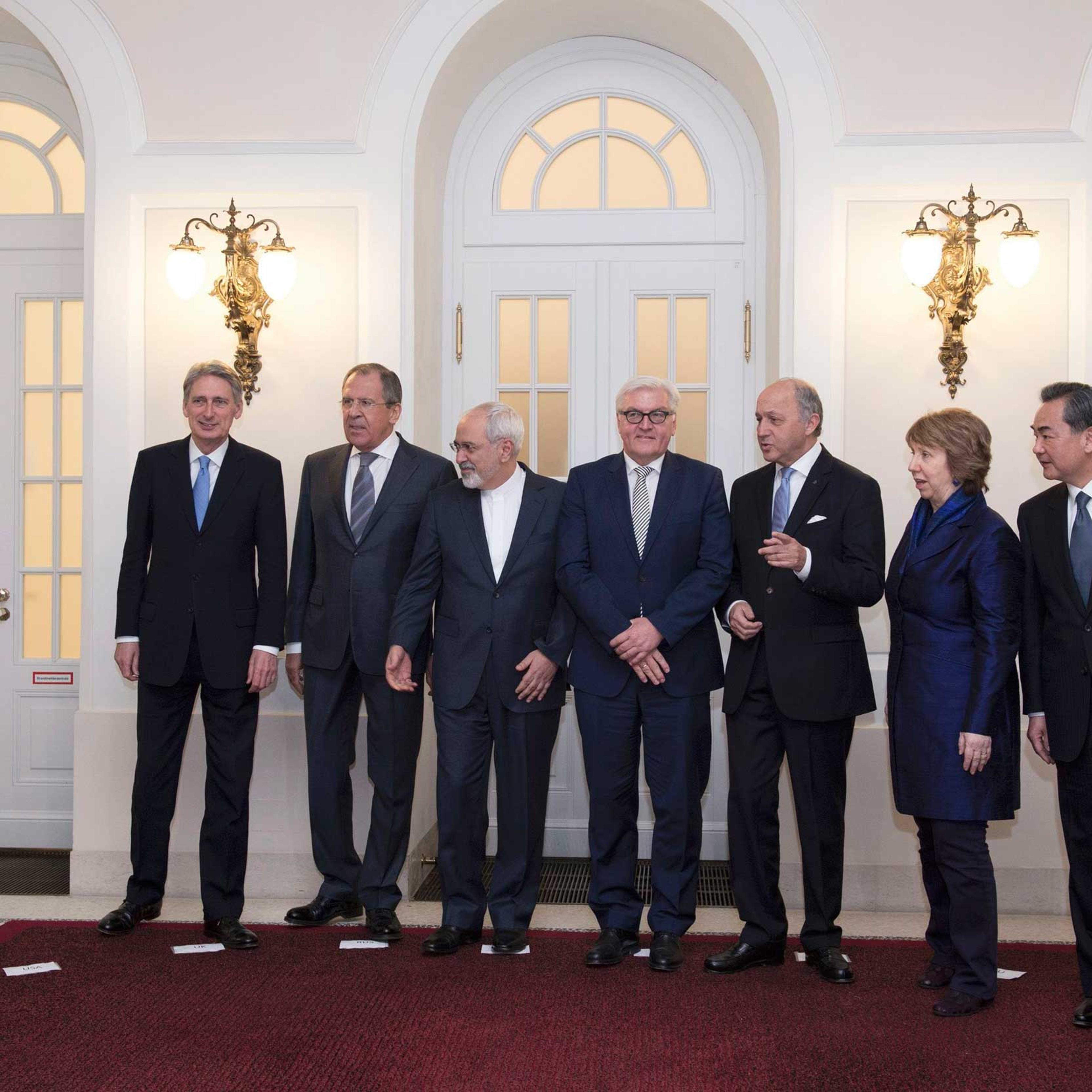 U.S. Secretary of State Kerry steps out as Britain's Foreign Secretary Hammond, Russian Foreign Minister Lavrov, Iranian FM Zarif and German FM Steinmeier, French FM Fabius, EU envoy Ashton and Chinese FM Yi pose in Vienna