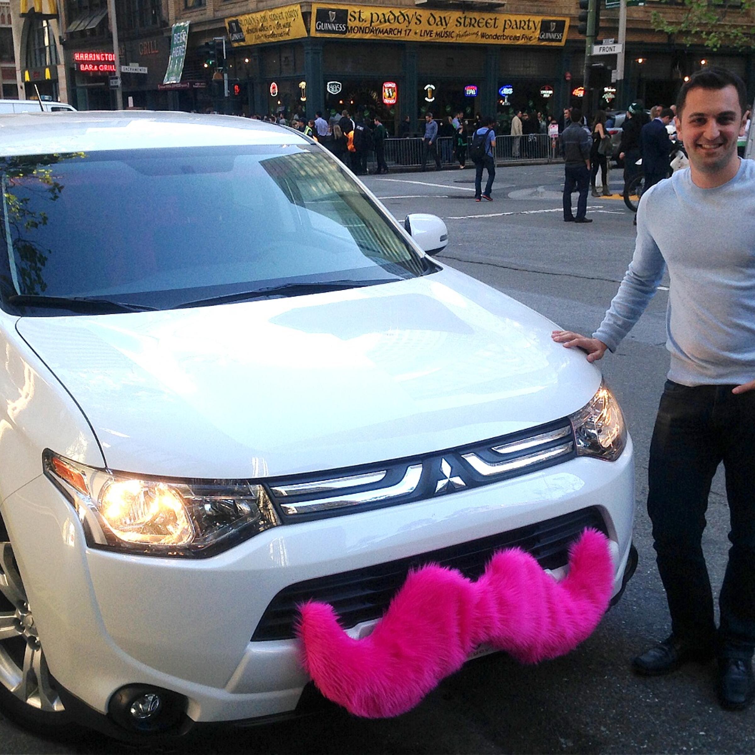 Lyft CEO John Zimmer poses with his ride in San Francisco on March 17, 2014