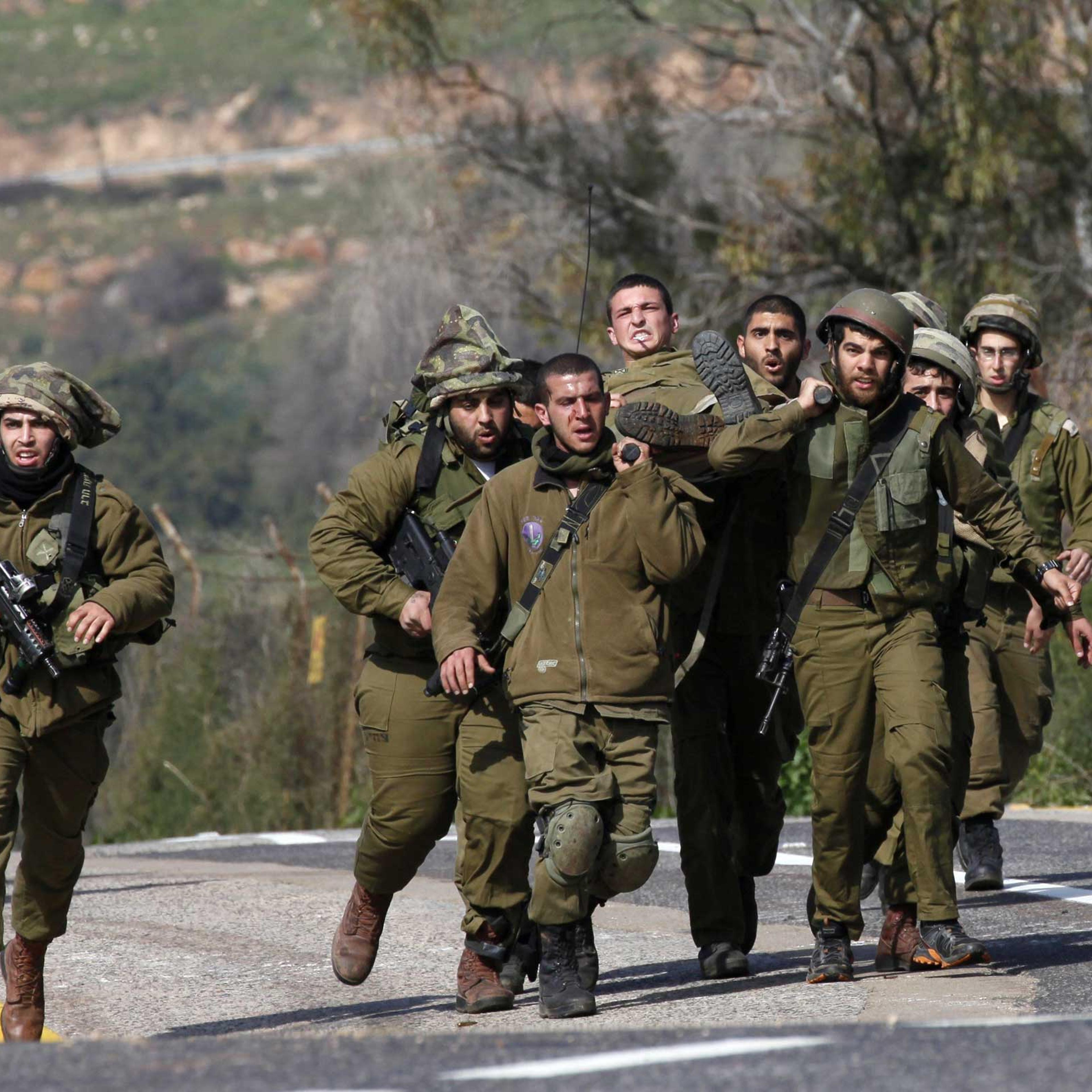 Israeli soldiers carry an injured comrade after an anti-tank missile hit an army vehicle in an occupied area on the border with Lebanon on Jan. 28, 2015.