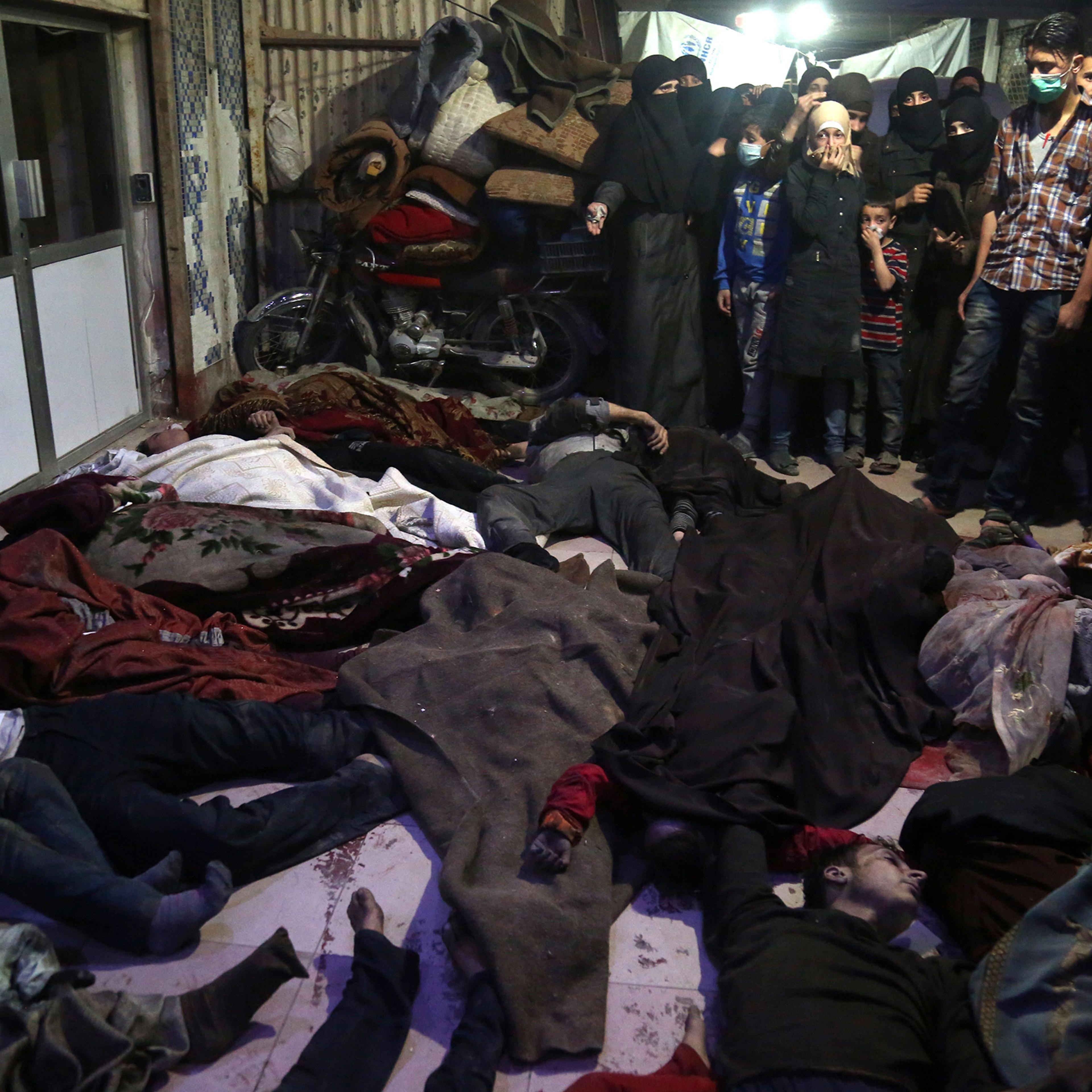 Survivors and medical workers survey victims of the suspected chemical-weapons attack