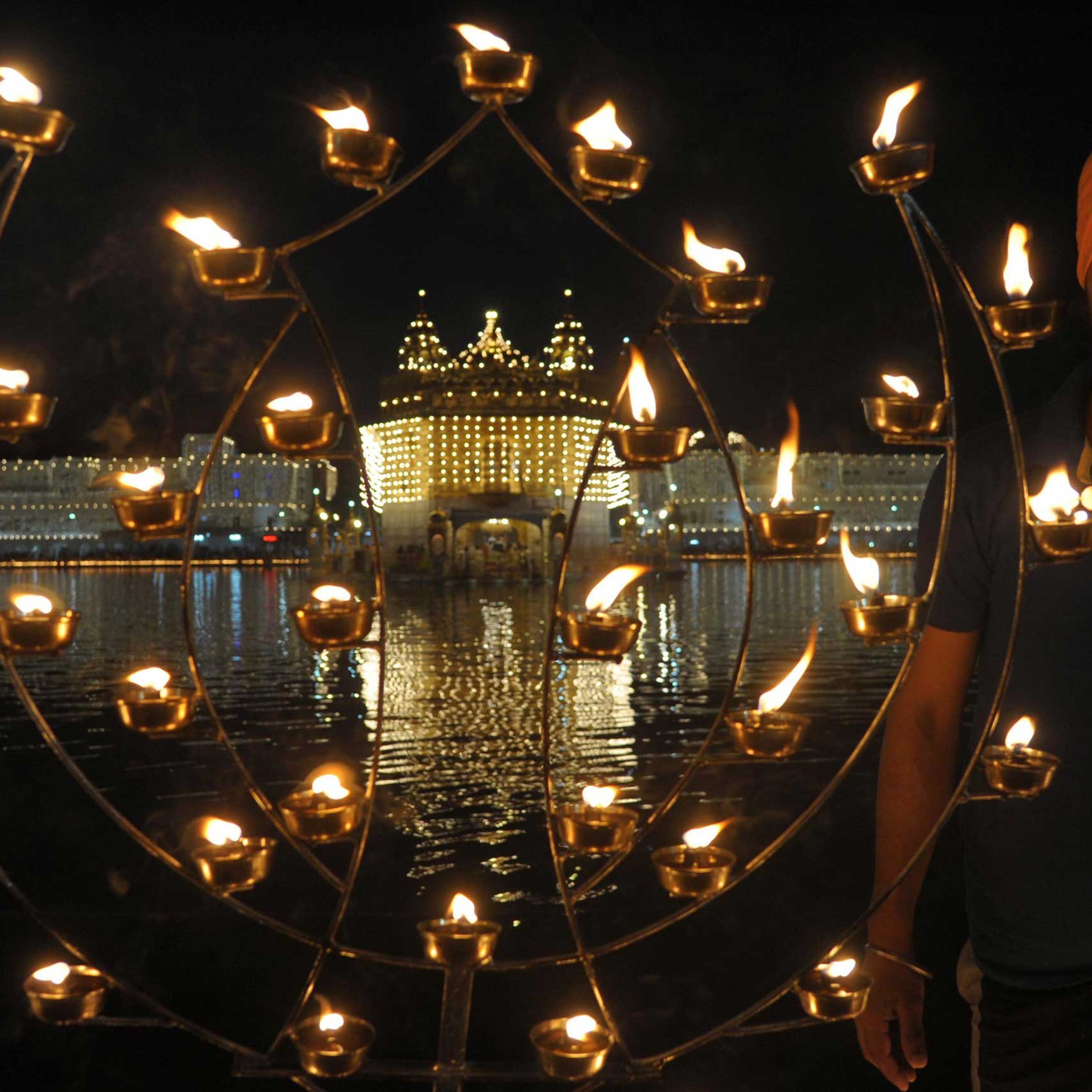 An Indian Sikh devotee lights candles on the occasion of Bandi Chhor Divas, or Diwali, at the illuminated Golden Temple in Amritsar, India on Oct. 23, 2014.