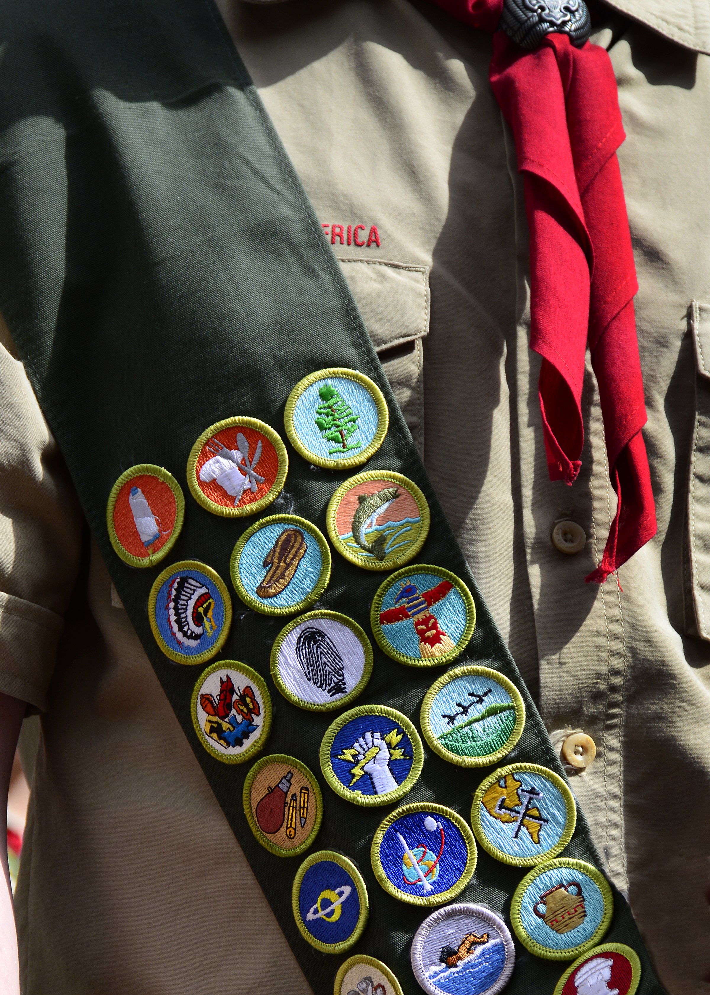 A Boy Scout wears a sash displaying his earned merit badges at a ceremony in New York City. The merit badge sash is worn by a Boy Scout during formal activities and events and not during Troop meetings or campouts.