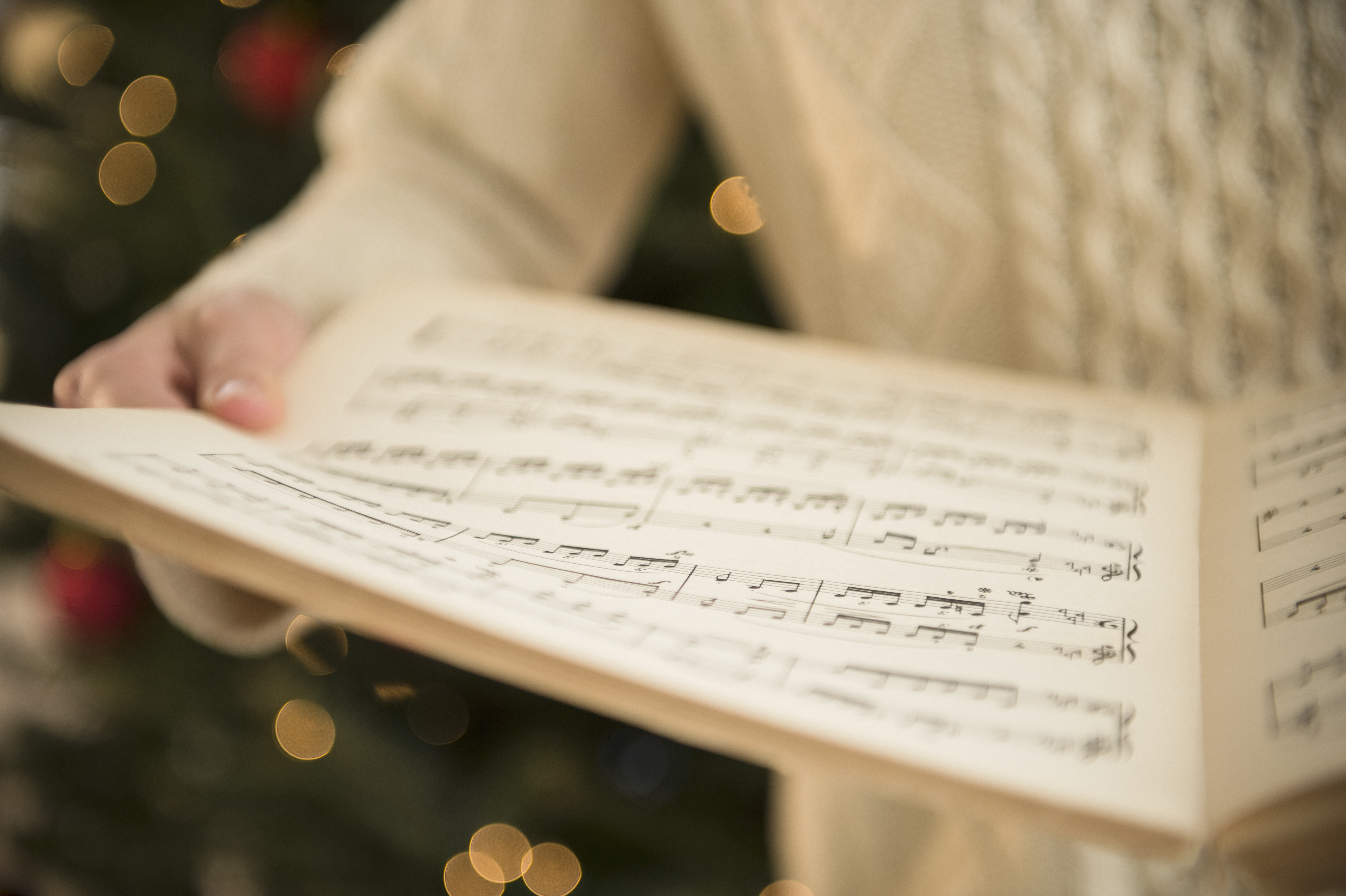 person-holding-sheet-music