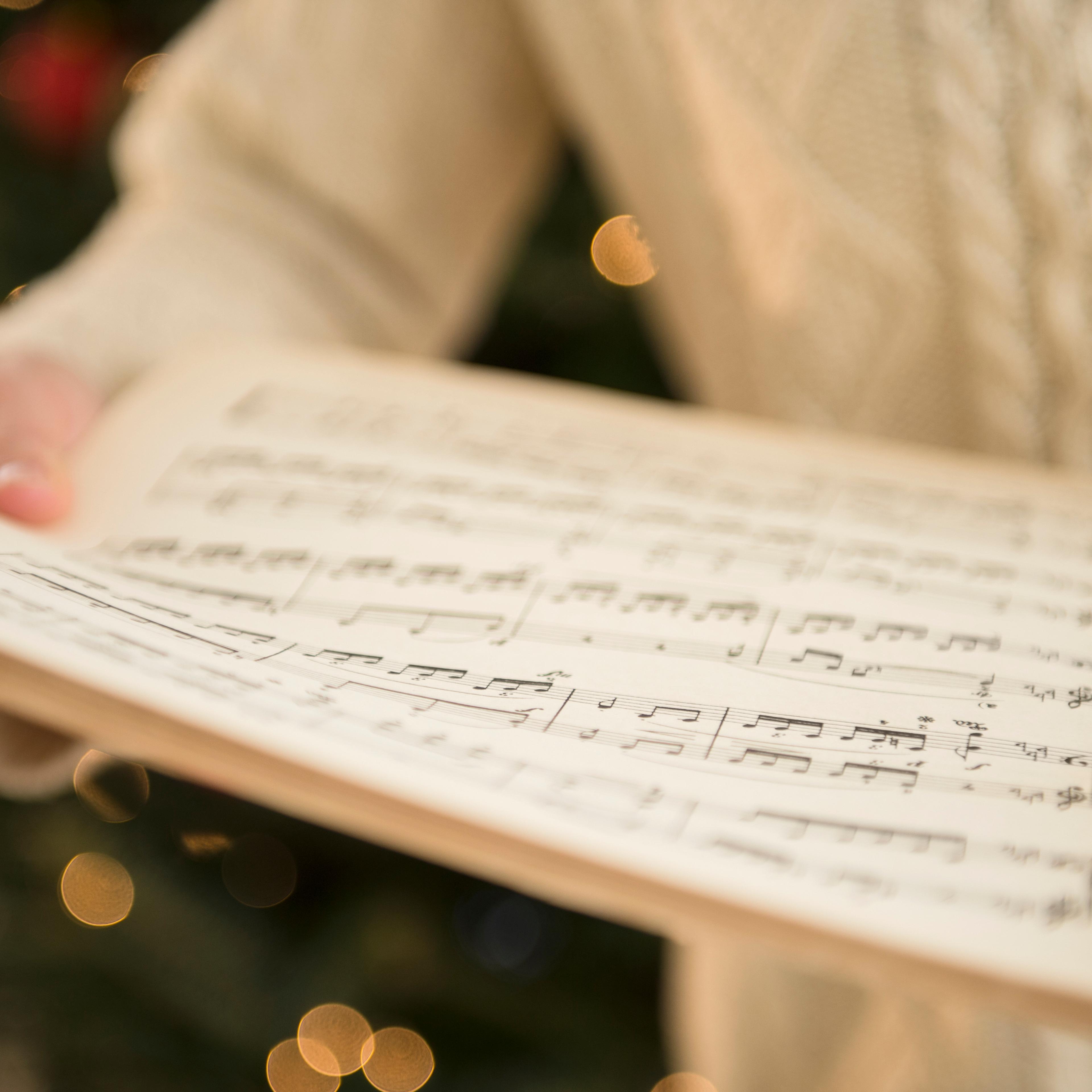 person-holding-sheet-music
