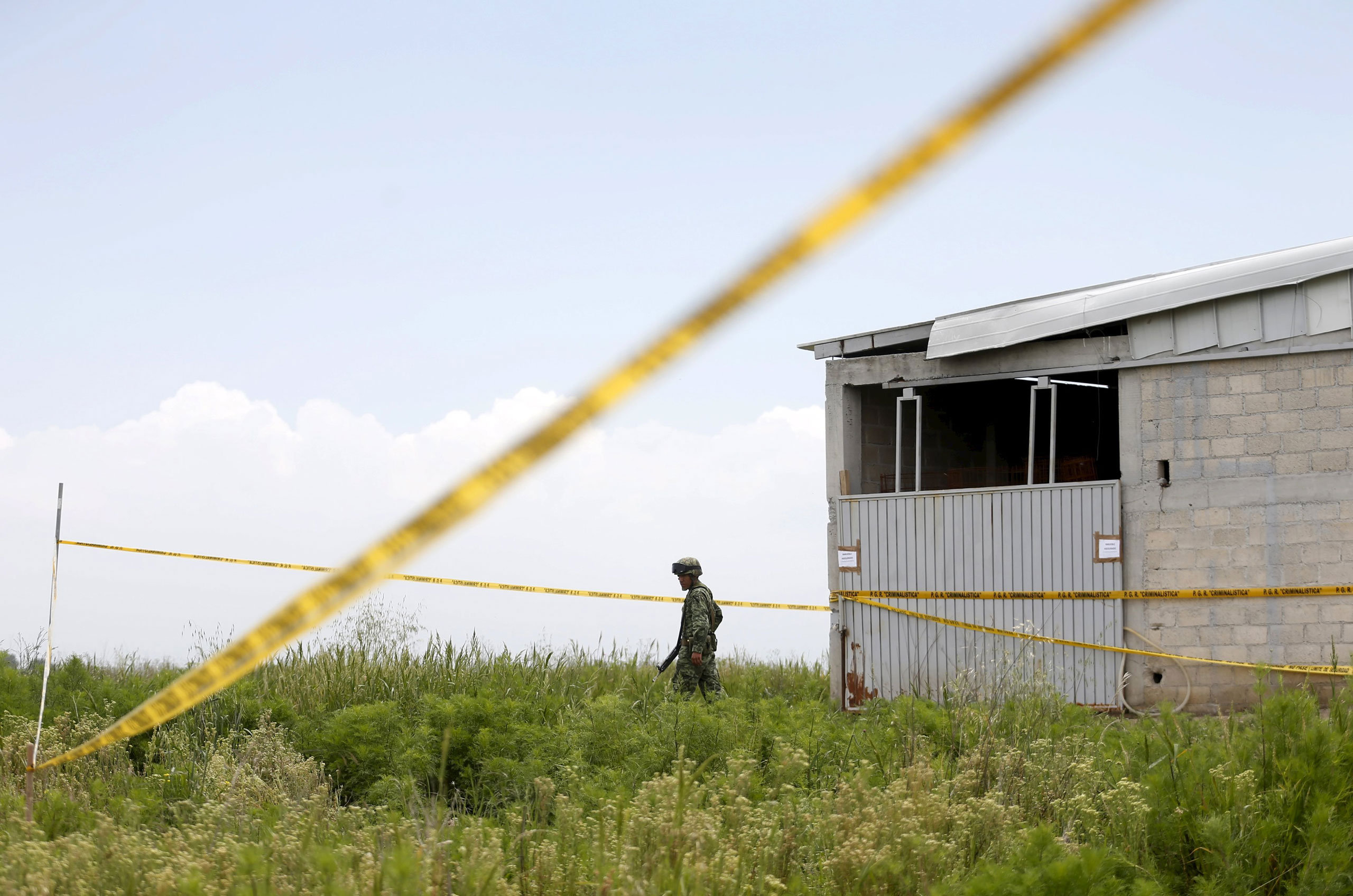 A soldier keeps watch outside a warehouse containing a tunnel, connected to the Altiplano Federal Penitentiary and used by drug lord Joaquin 'El Chapo' Guzman to escape, in Almoloya de Juarez, on the outskirts of Mexico City, July 14 , 2015. Mexican auth
