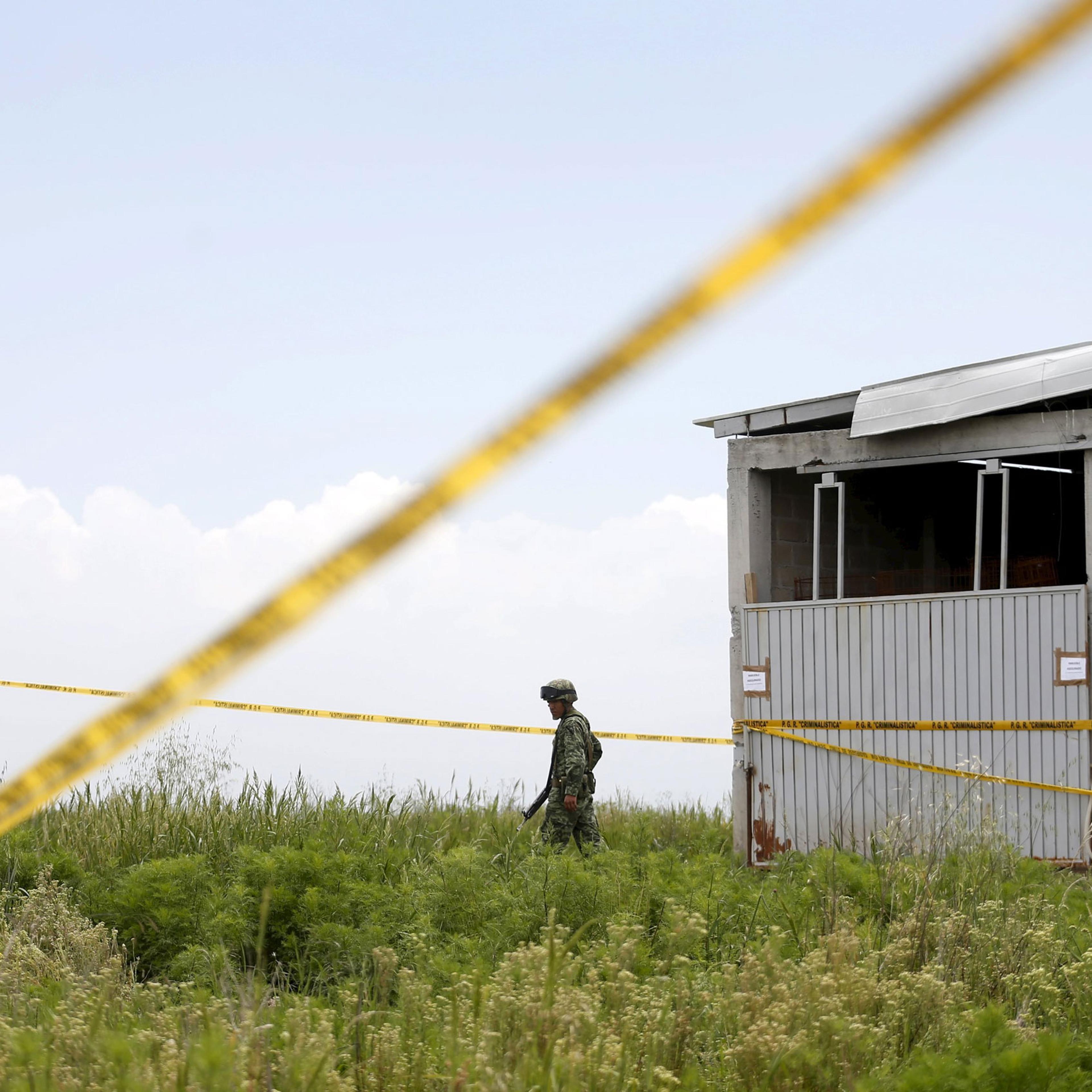 A soldier keeps watch outside a warehouse containing a tunnel, connected to the Altiplano Federal Penitentiary and used by drug lord Joaquin 'El Chapo' Guzman to escape, in Almoloya de Juarez, on the outskirts of Mexico City, July 14 , 2015. Mexican auth
