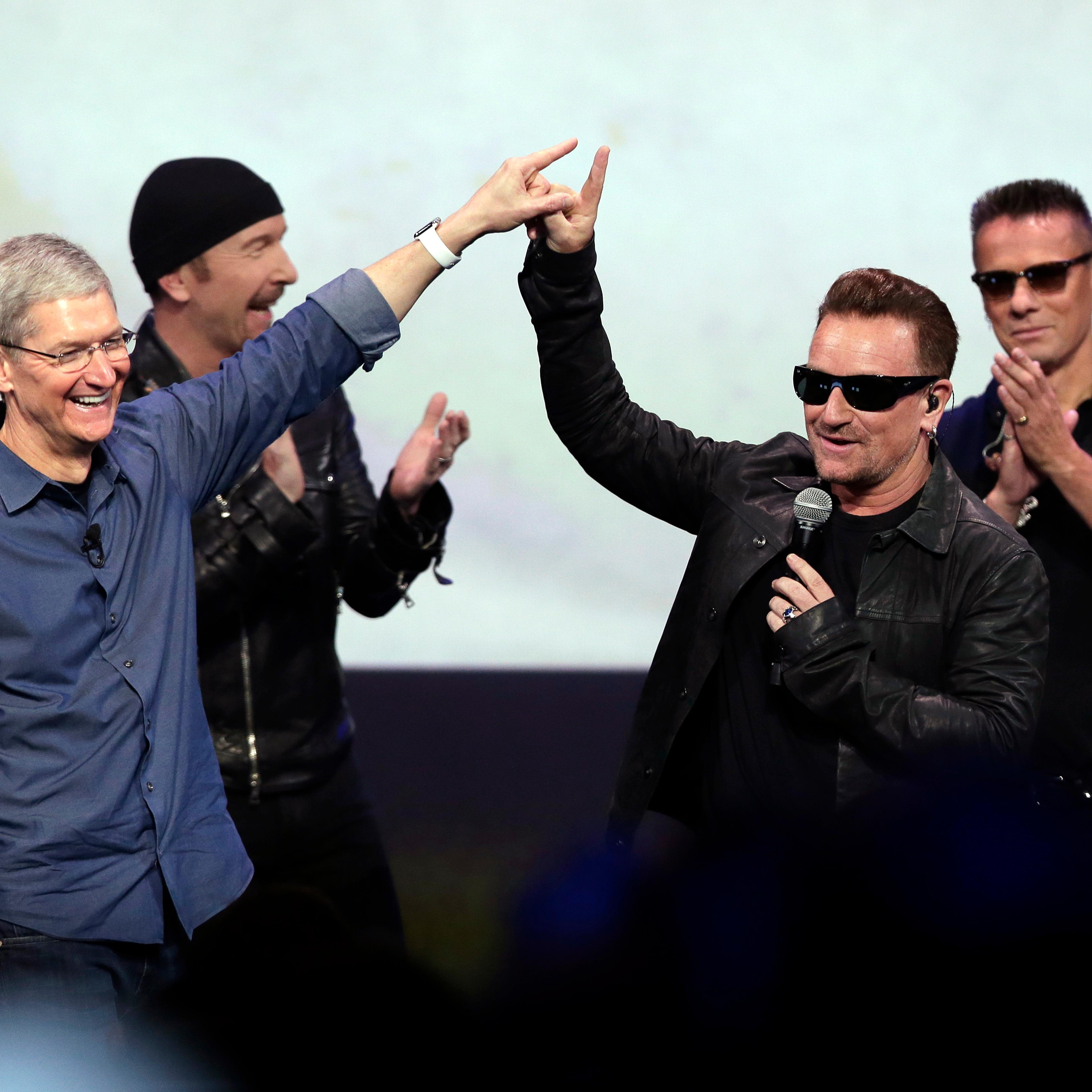 In this Sept. 9, 2014 file photo, Apple CEO Tim Cook (L) greets Bono from the band U2 after they preformed at the end of the Apple event in Cupertino, Calif.