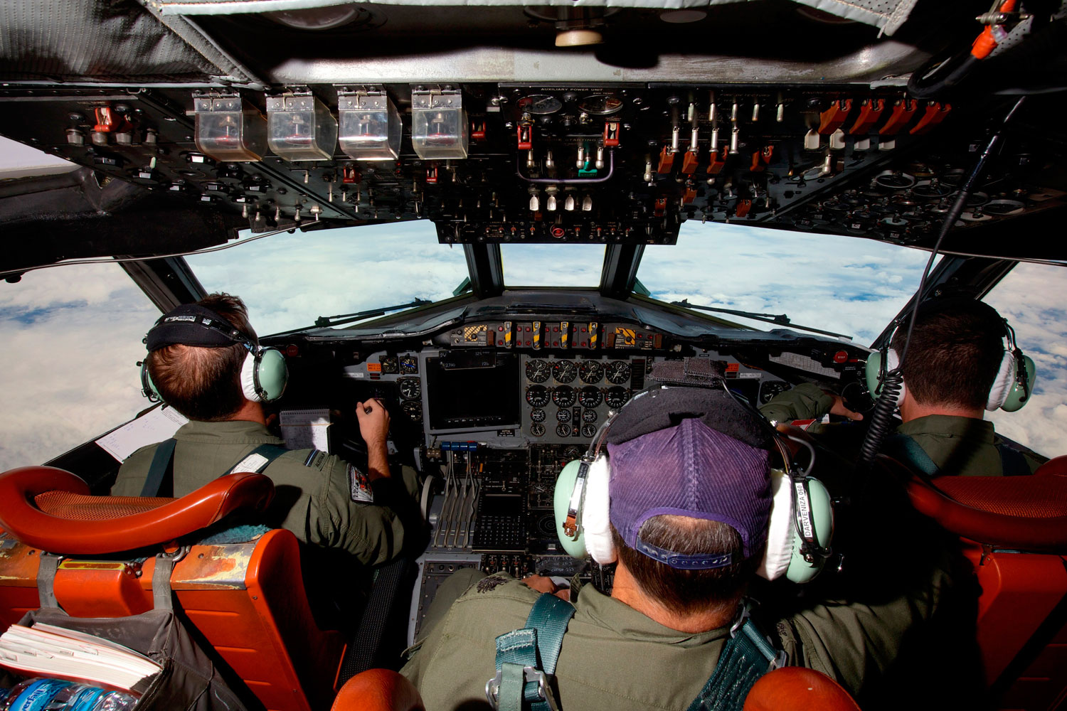 Co-Pilot Flying Officer Marc Smith (L) and crewmen fly at high altitude aboard a Royal Australian Air Force (RAAF) AP-3C Orion aircraft after searching for the missing Malaysian Airlines Flight MH370 over the southern Indian Ocean March 24, 2014.