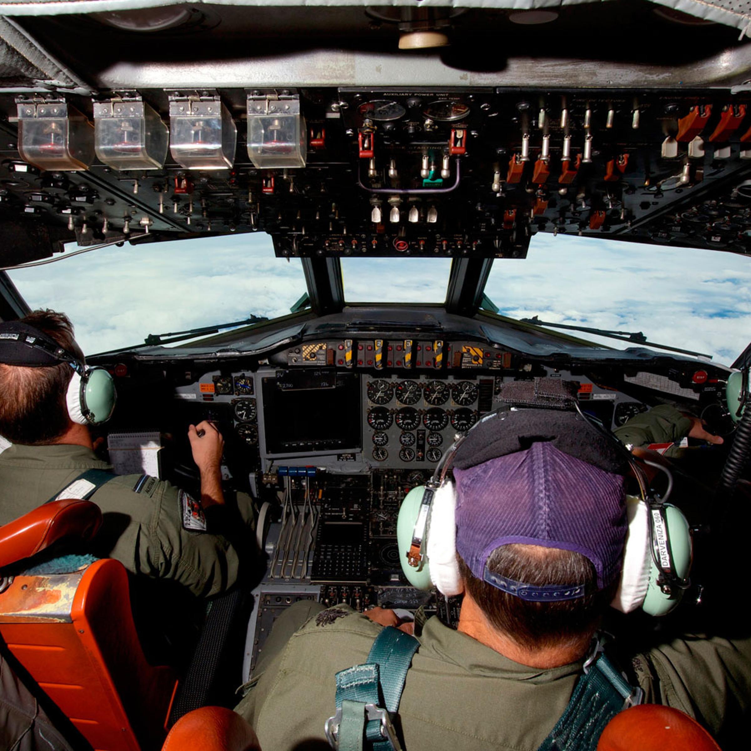 Co-Pilot Flying Officer Marc Smith (L) and crewmen fly at high altitude aboard a Royal Australian Air Force (RAAF) AP-3C Orion aircraft after searching for the missing Malaysian Airlines Flight MH370 over the southern Indian Ocean March 24, 2014.