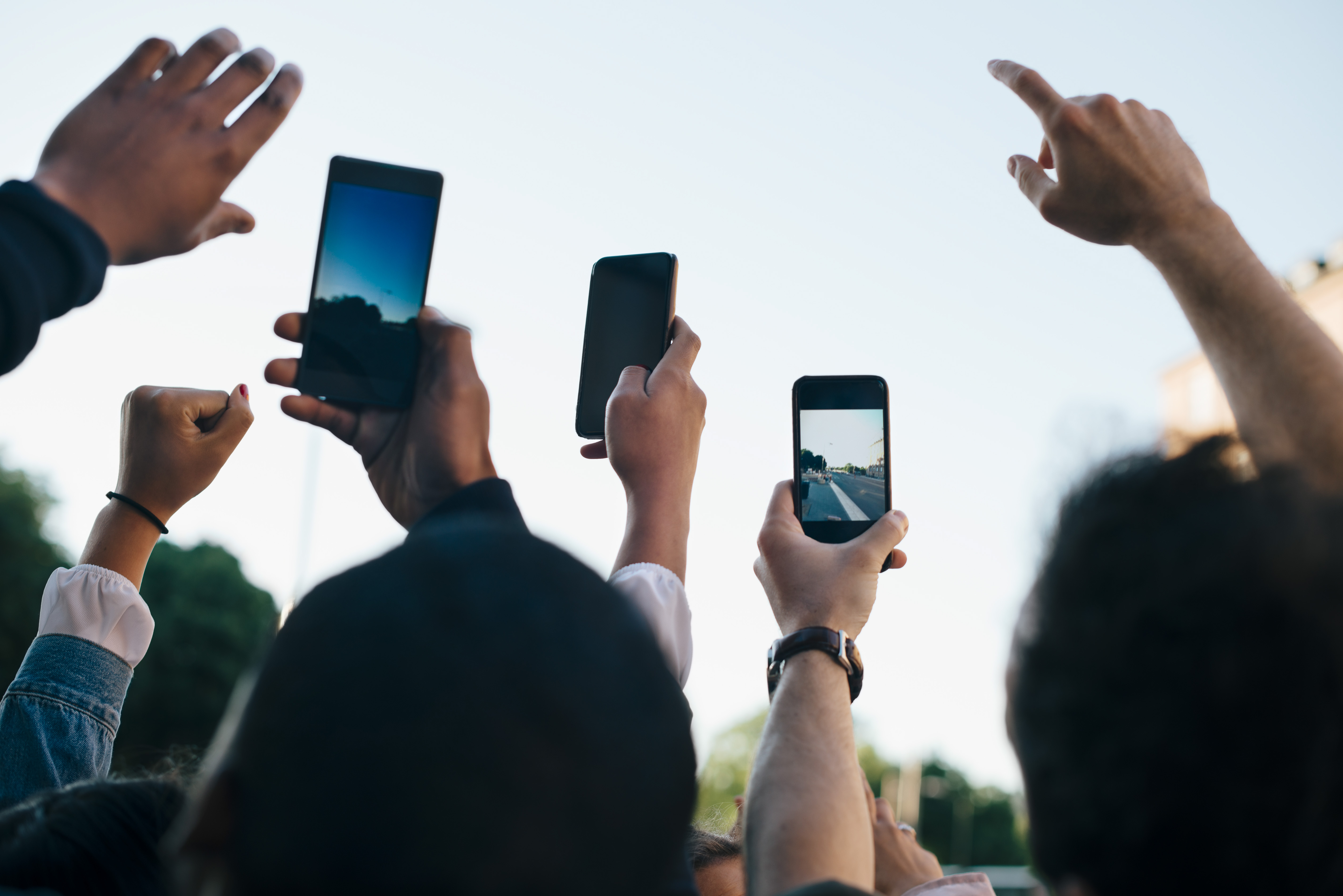 A group of friends photographing the sky with smartphones
