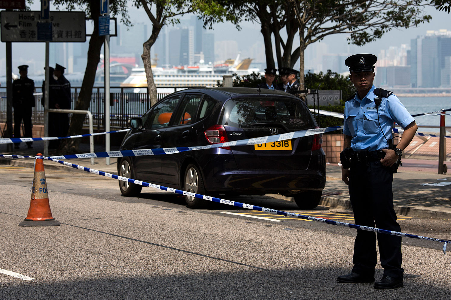 A policeman stands guard next to former Ming Pao chief editor Kevin Lau's car after Lau suffered from a chopper attack in Hong Kong Feb. 26, 2014