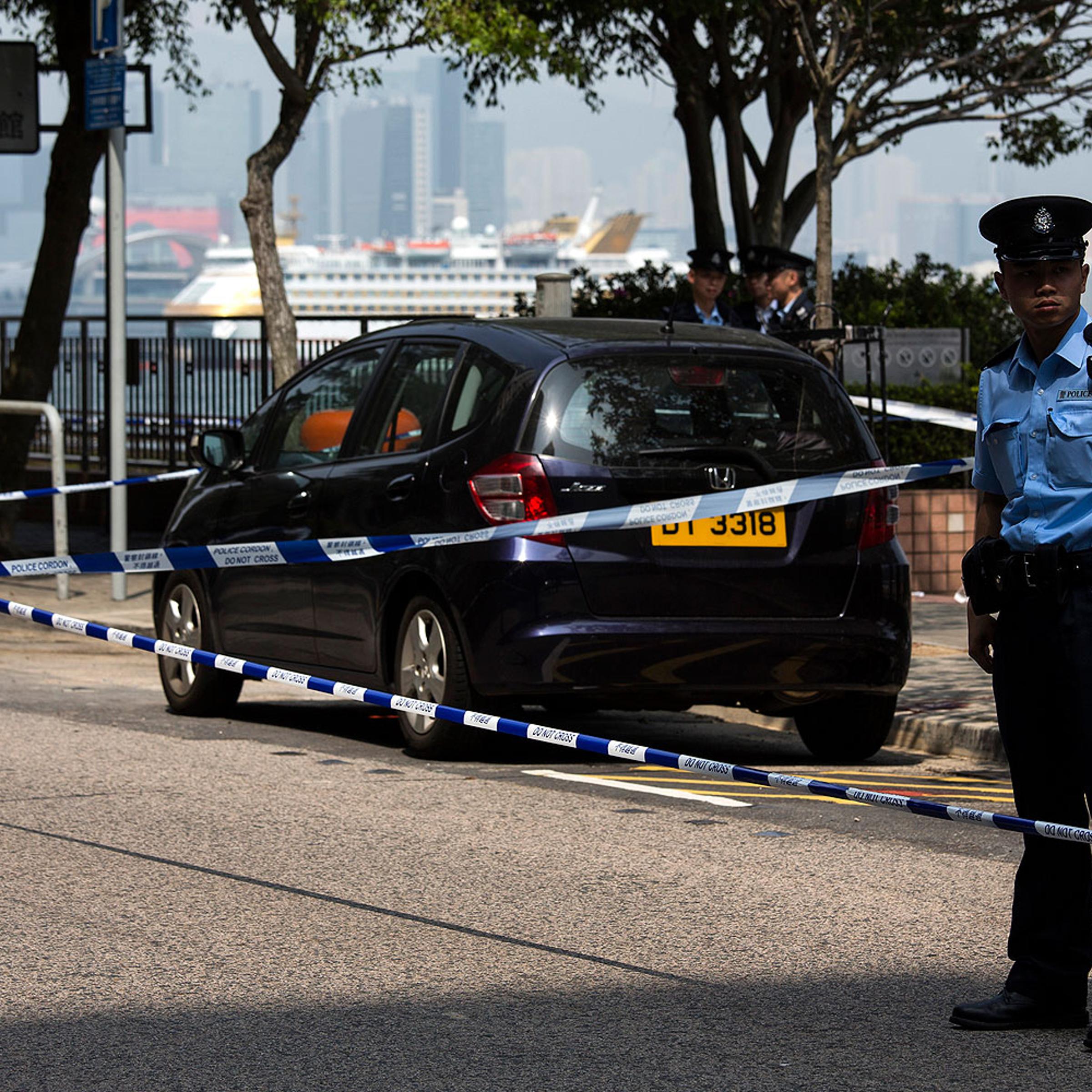 A policeman stands guard next to former Ming Pao chief editor Kevin Lau's car after Lau suffered from a chopper attack in Hong Kong Feb. 26, 2014
