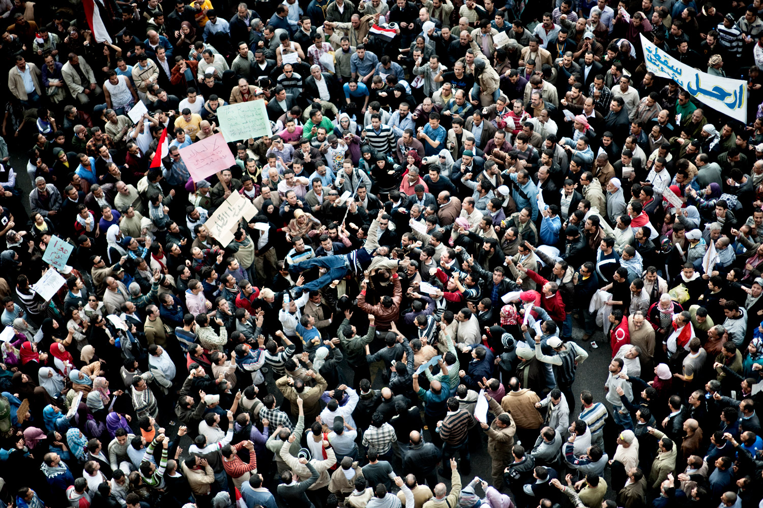 Egyptian demonstrators calling for the end of the Mubarak regime lift a demonstrator during a march on Tahrir square on Feb. 1, 2011. 