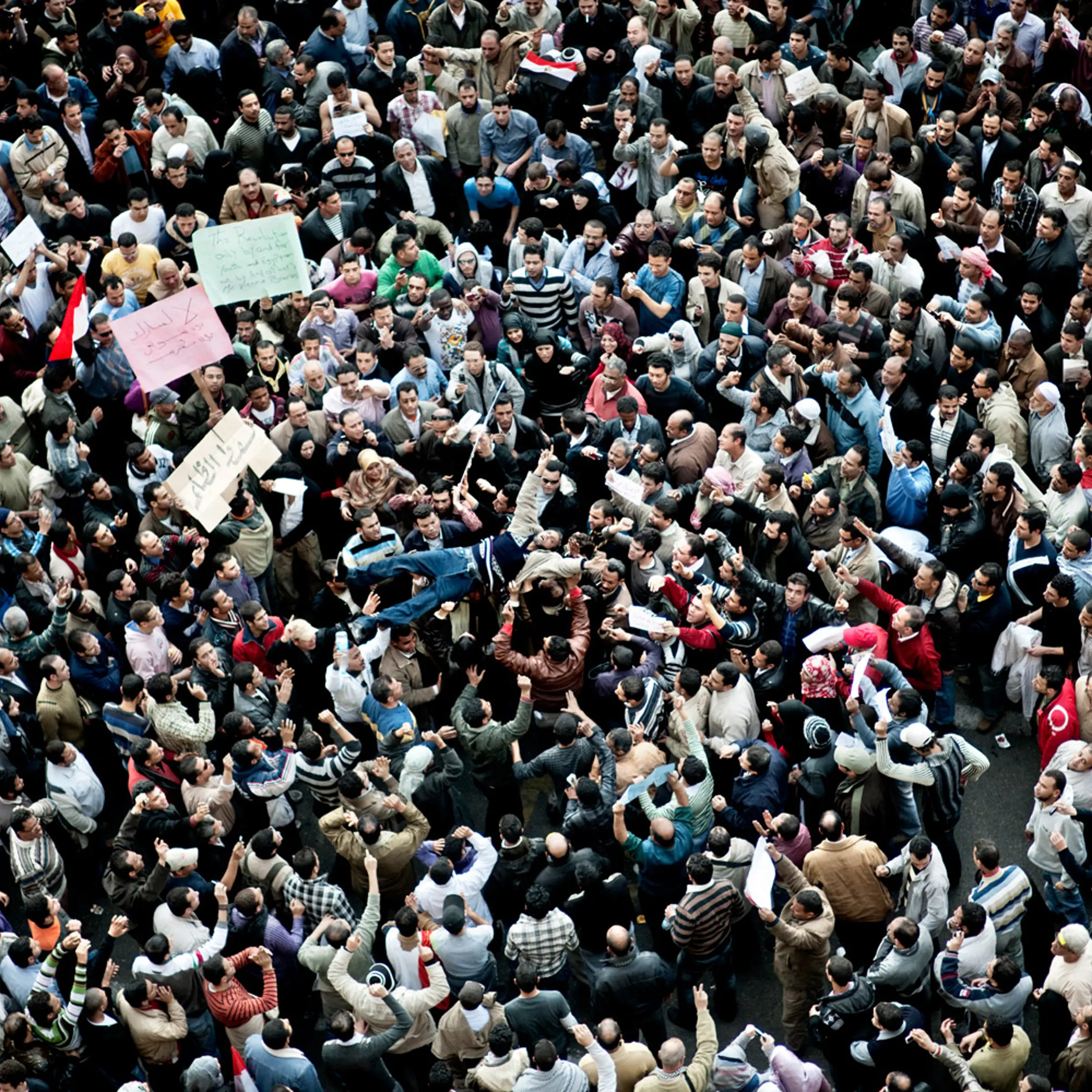 Egyptian demonstrators calling for the end of the Mubarak regime lift a demonstrator during a march on Tahrir square on Feb. 1, 2011.
