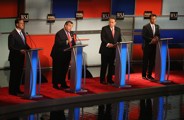 Presidential candidate New Jersey Gov. Chris Christie (2nd L) speaks while Rick Santorum, Mike Huckabee, and Louisiana Gov. Bobby Jindal look on during the Republican Presidential Debate sponsored by Fox Business and the Wall Street Journal at the Milwau