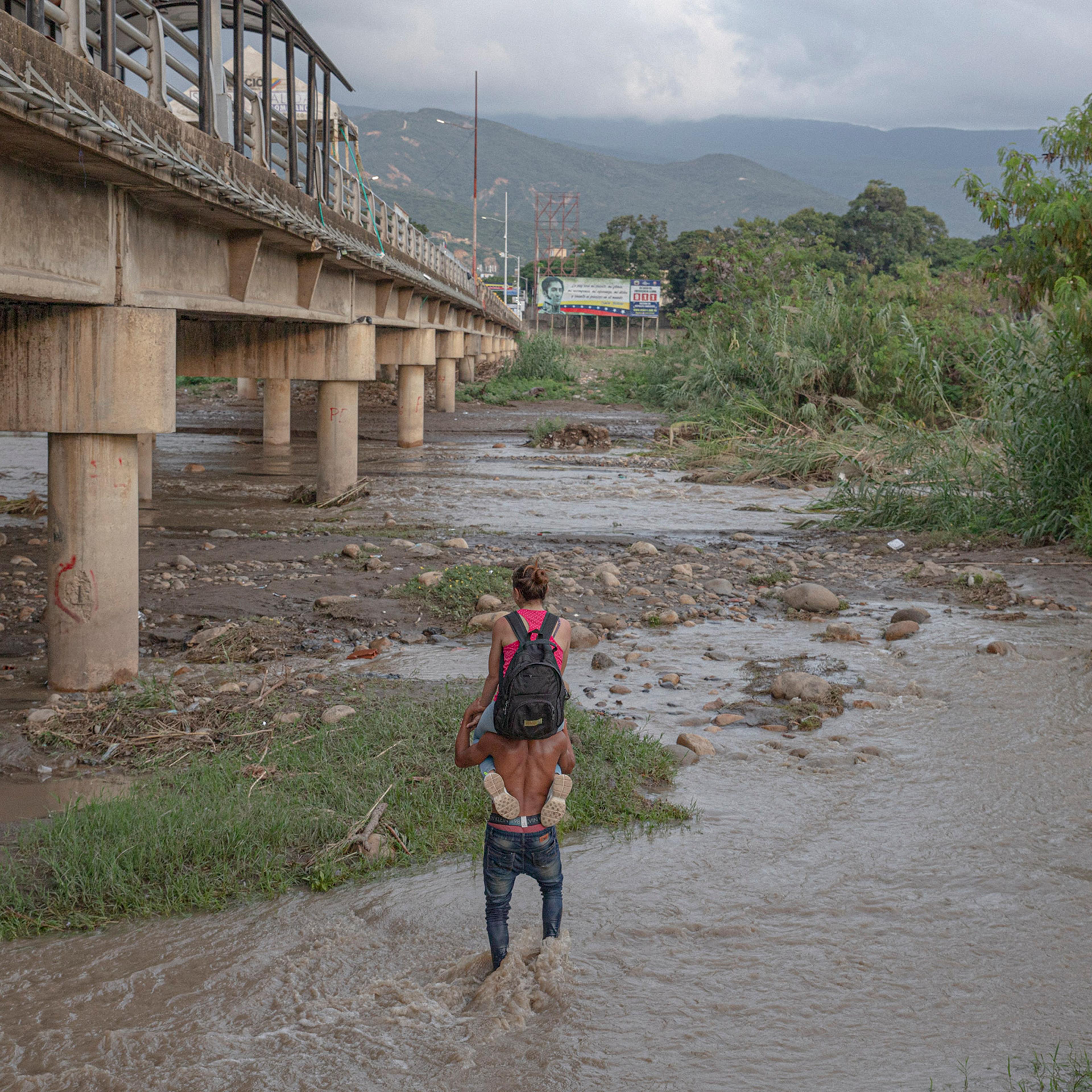 A man carries a woman across the Táchira River, which marks the border between Venezuela and Colombia, in November.