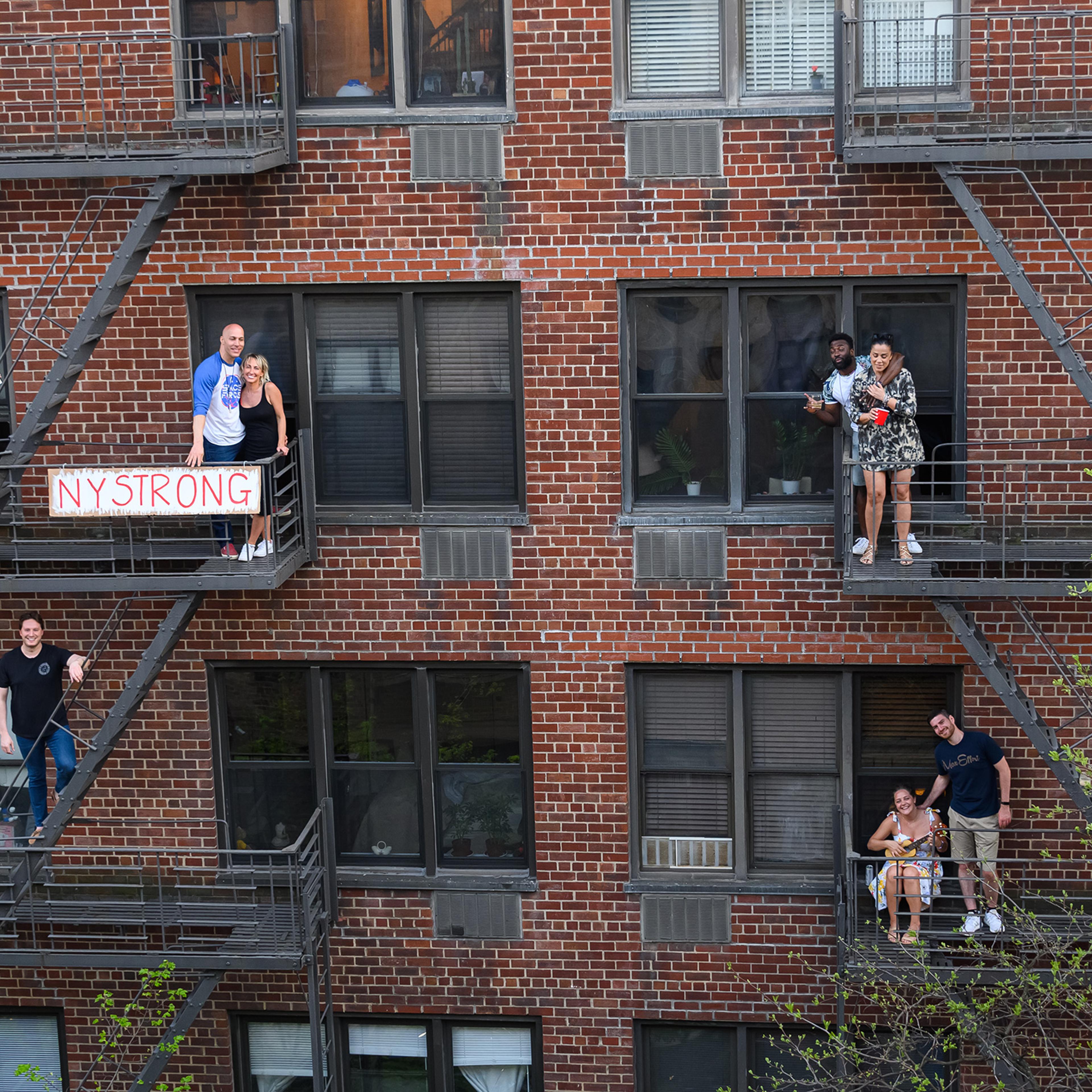 People applaud from their fire escapes to show their gratitude to medical staff and essential workers on the front lines of the coronavirus pandemic during the coronavirus pandemic in the Upper East Side on May 2nd in New York City.