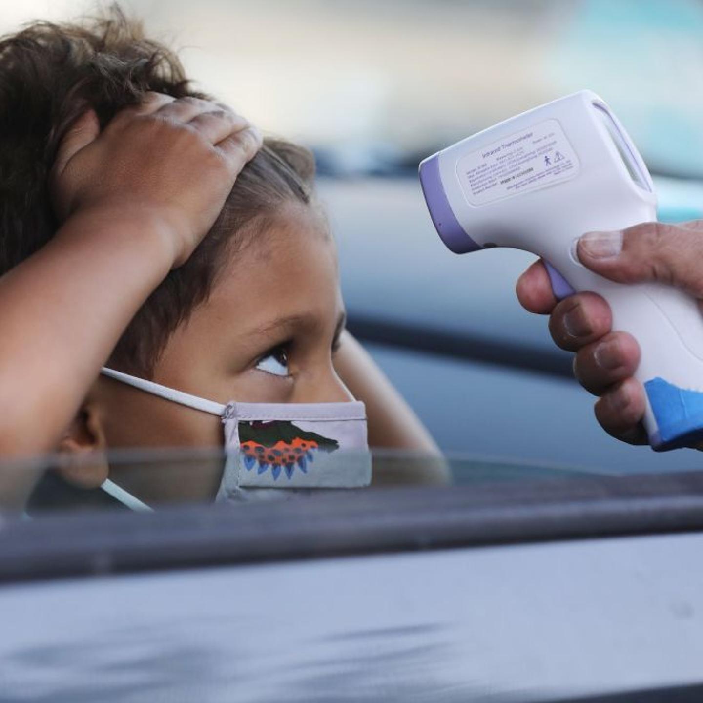 A student receives a temperature check before leaving the car to enter STAR Eco Station Tutoring & Enrichment Center on September 2, 2020 in Culver City, California