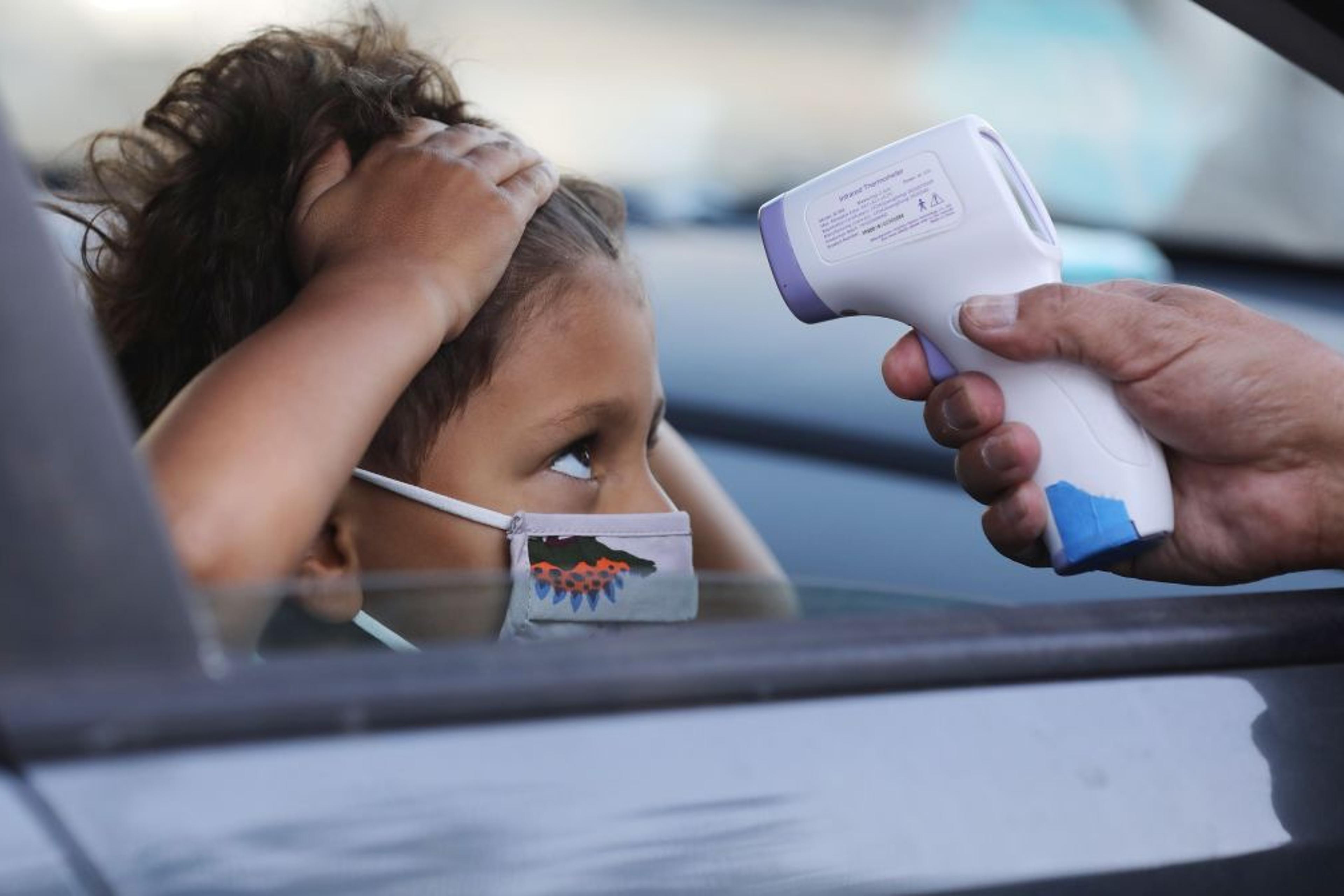 A student receives a temperature check before leaving the car to enter STAR Eco Station Tutoring & Enrichment Center on September 2, 2020 in Culver City, California