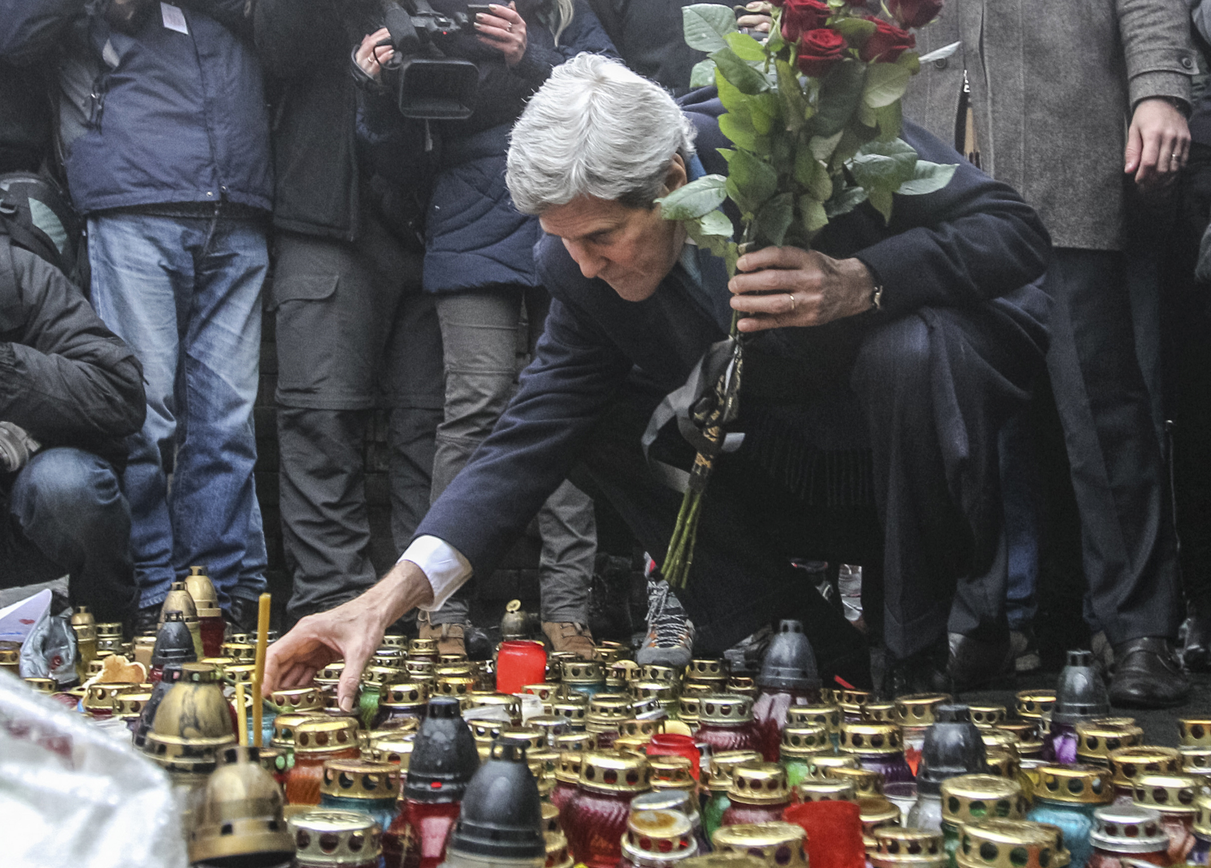 U.S. Secretary of State John Kerry lights a candle and lays roses atop the Shrine of the Fallen in Kiev