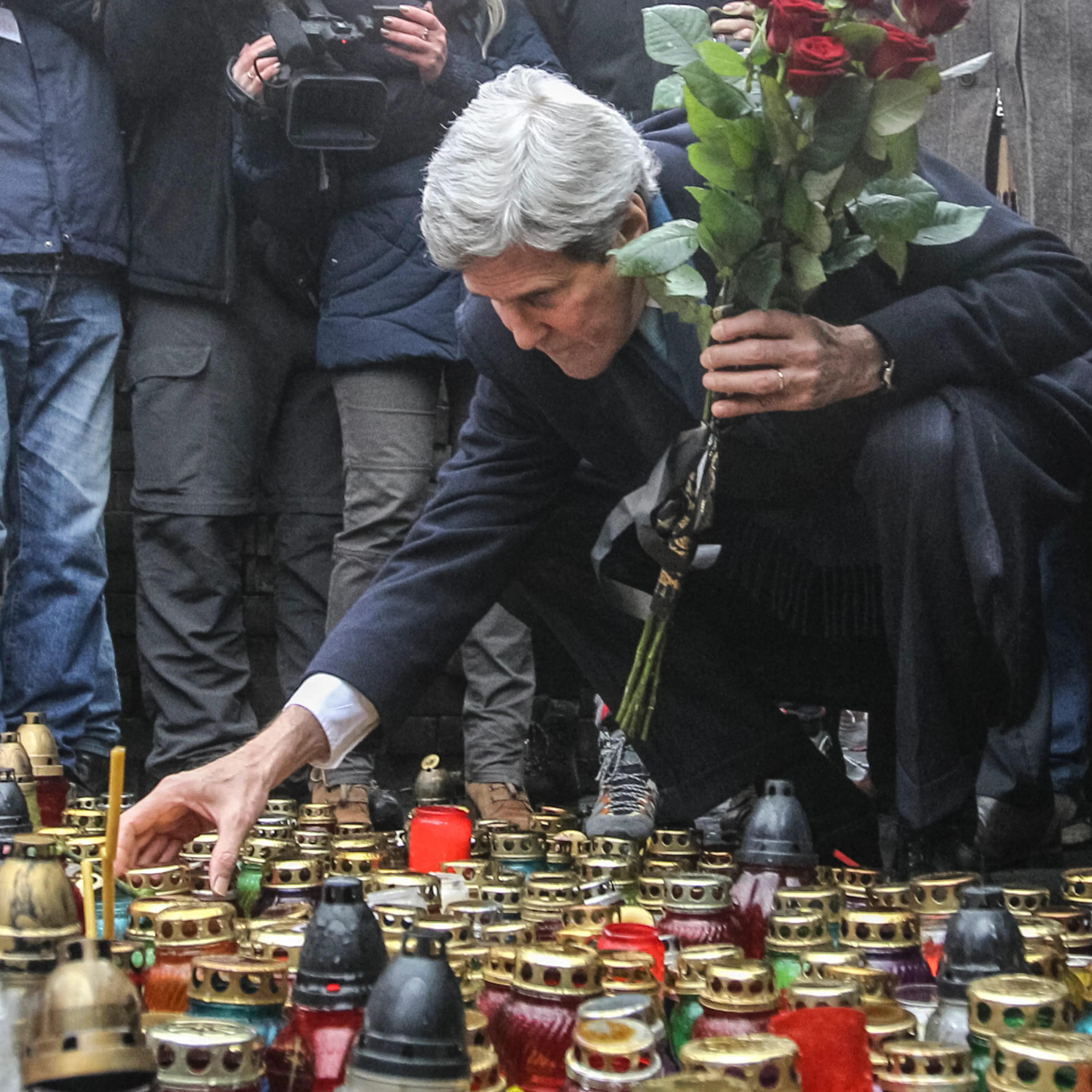 U.S. Secretary of State John Kerry lights a candle and lays roses atop the Shrine of the Fallen in Kiev