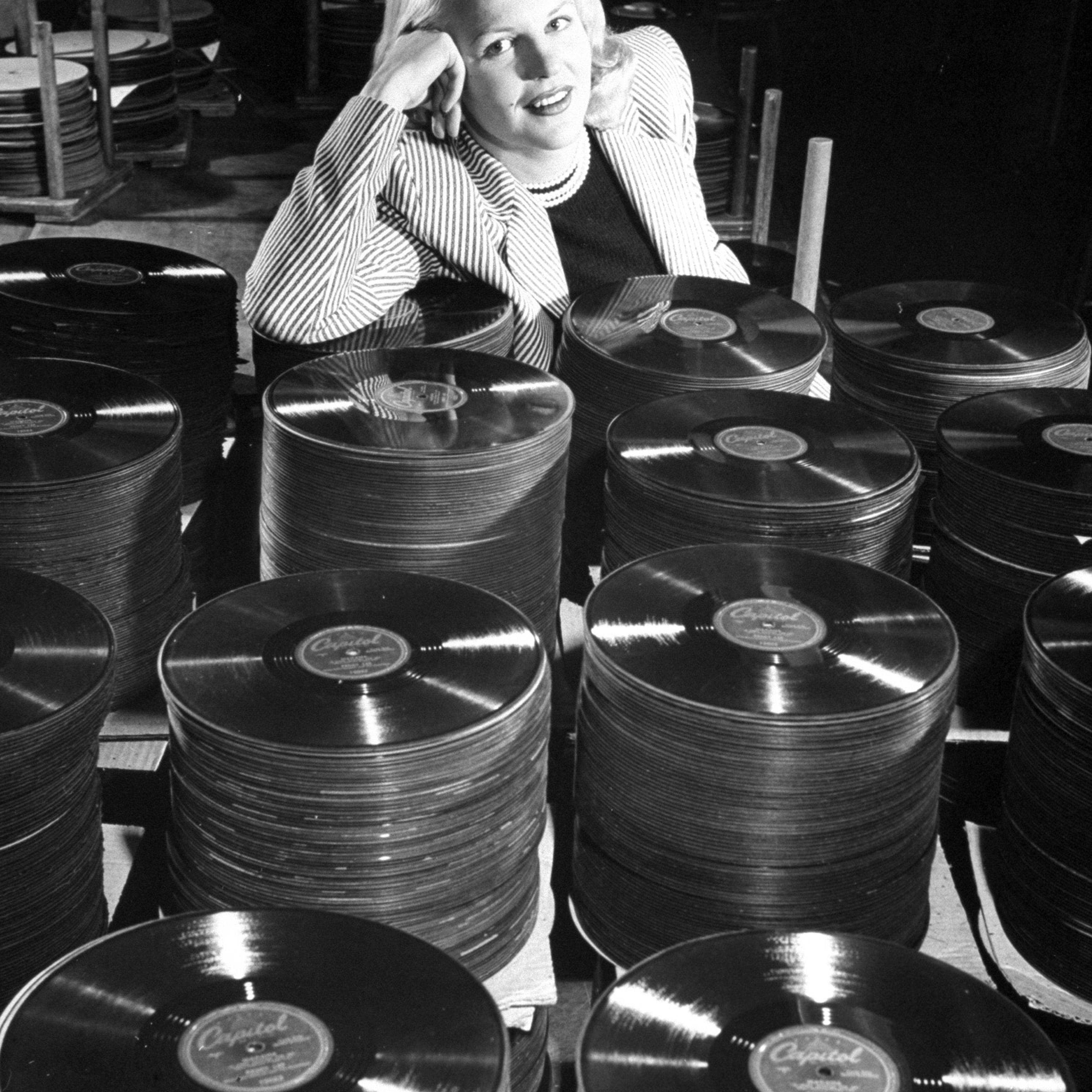 Singer Peggy Lee leans on a stack of records of her hit tune "Mañana." This record alone should bring in $75,000 in royalties in 1948.