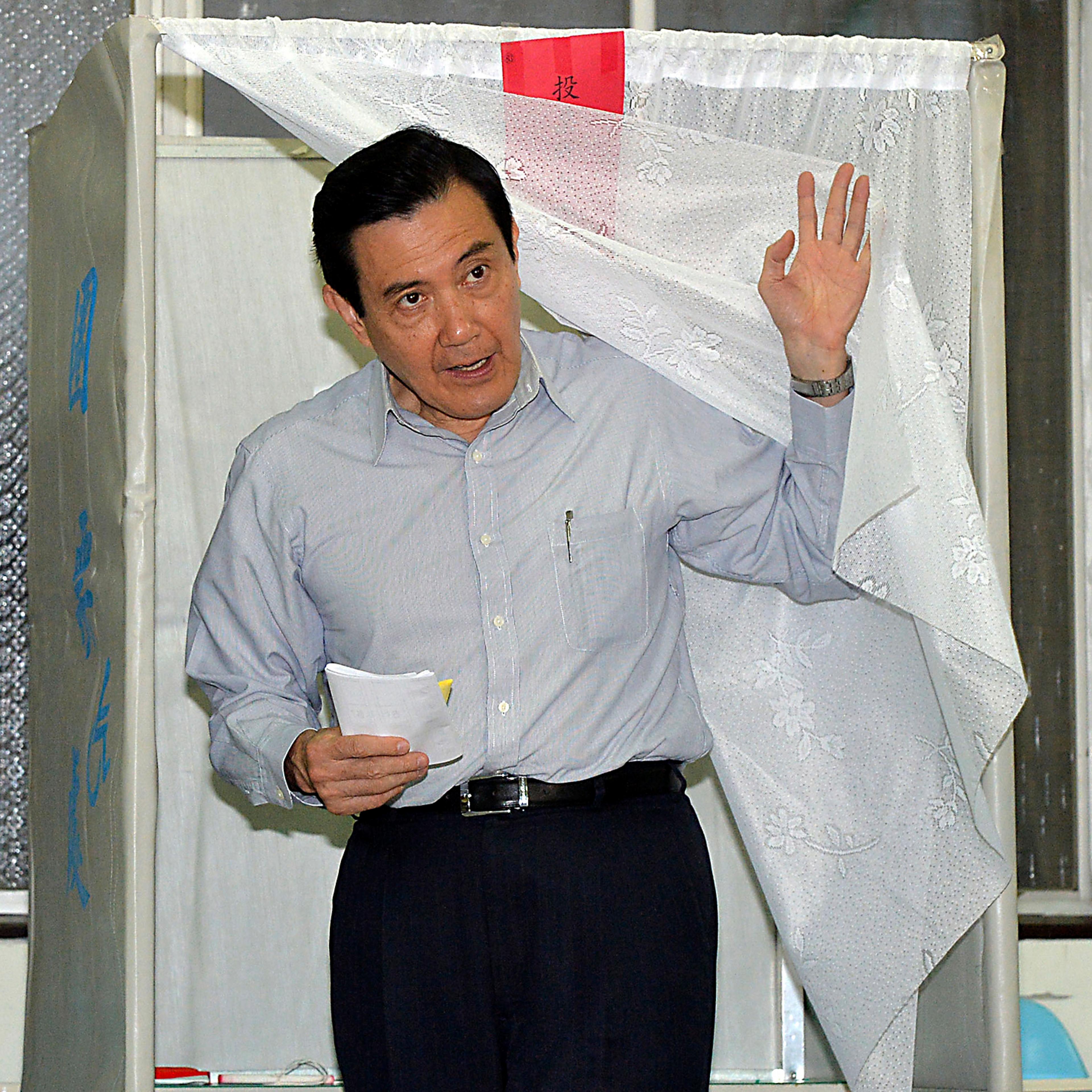 Taiwan's President Ma Ying-jeou walks out of a voting booth at a voting station during local elections in Taipei