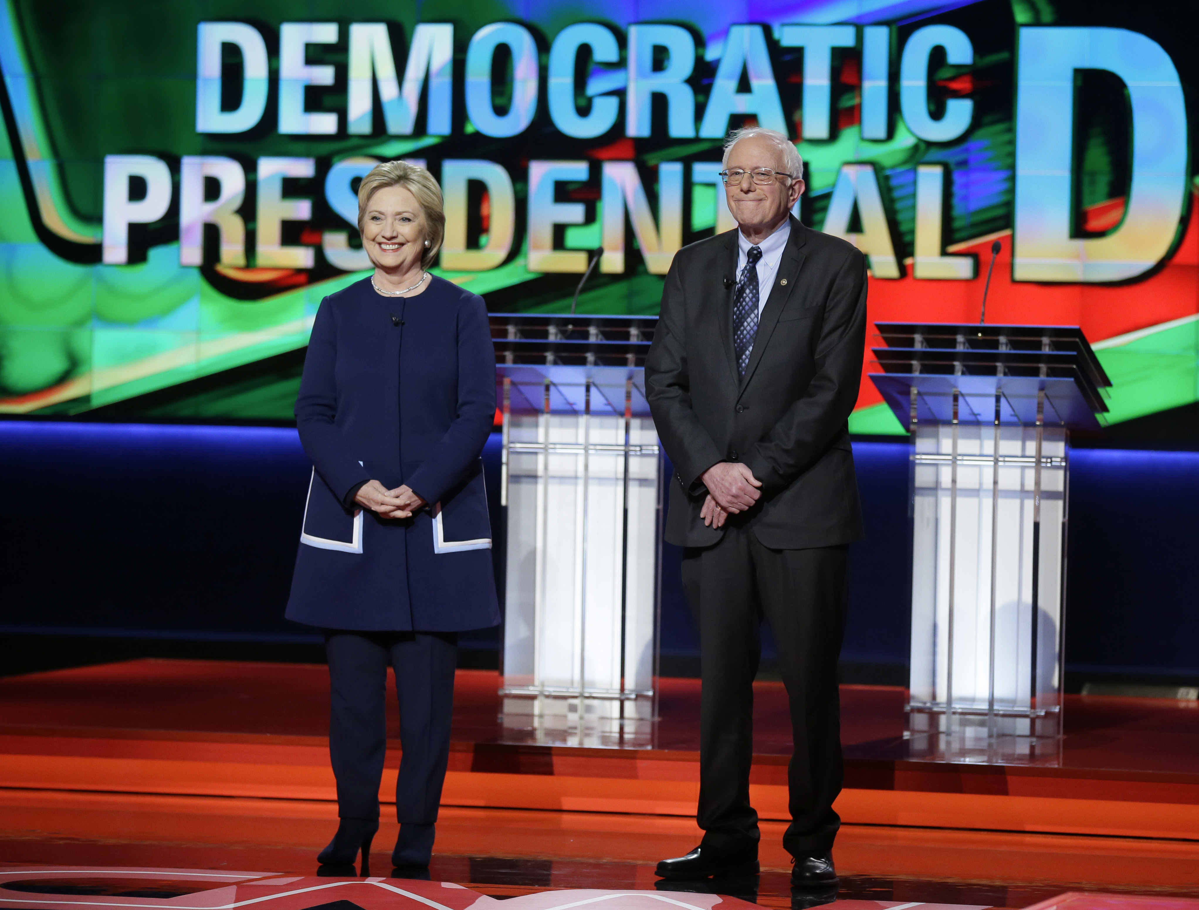 Hillary Clinton and Bernie Sanders stand stage before a Democratic presidential primary debate at the University of Michigan-Flint in Flint, Mich. on March 6, 2016.