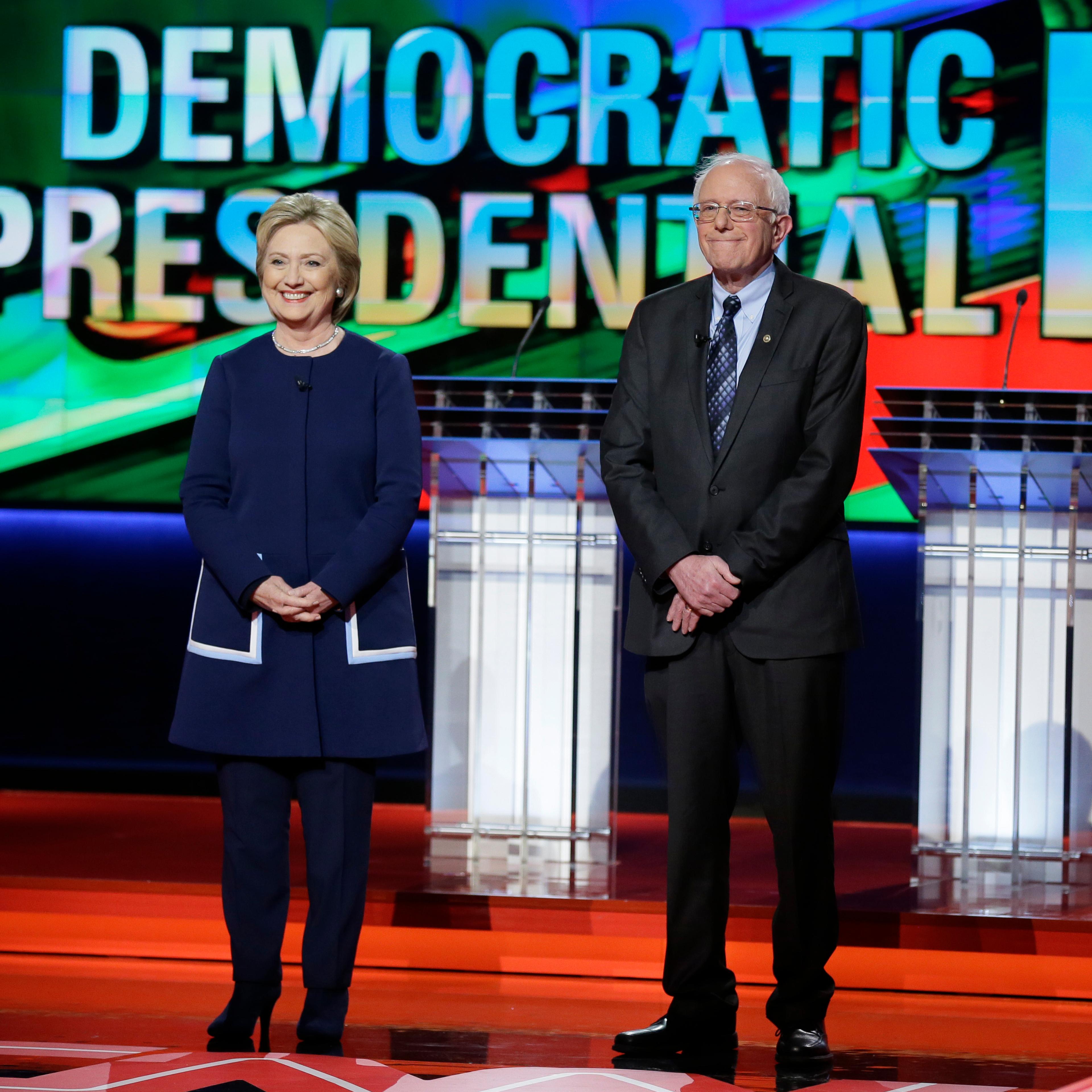 Hillary Clinton and Bernie Sanders stand stage before a Democratic presidential primary debate at the University of Michigan-Flint in Flint, Mich. on March 6, 2016.