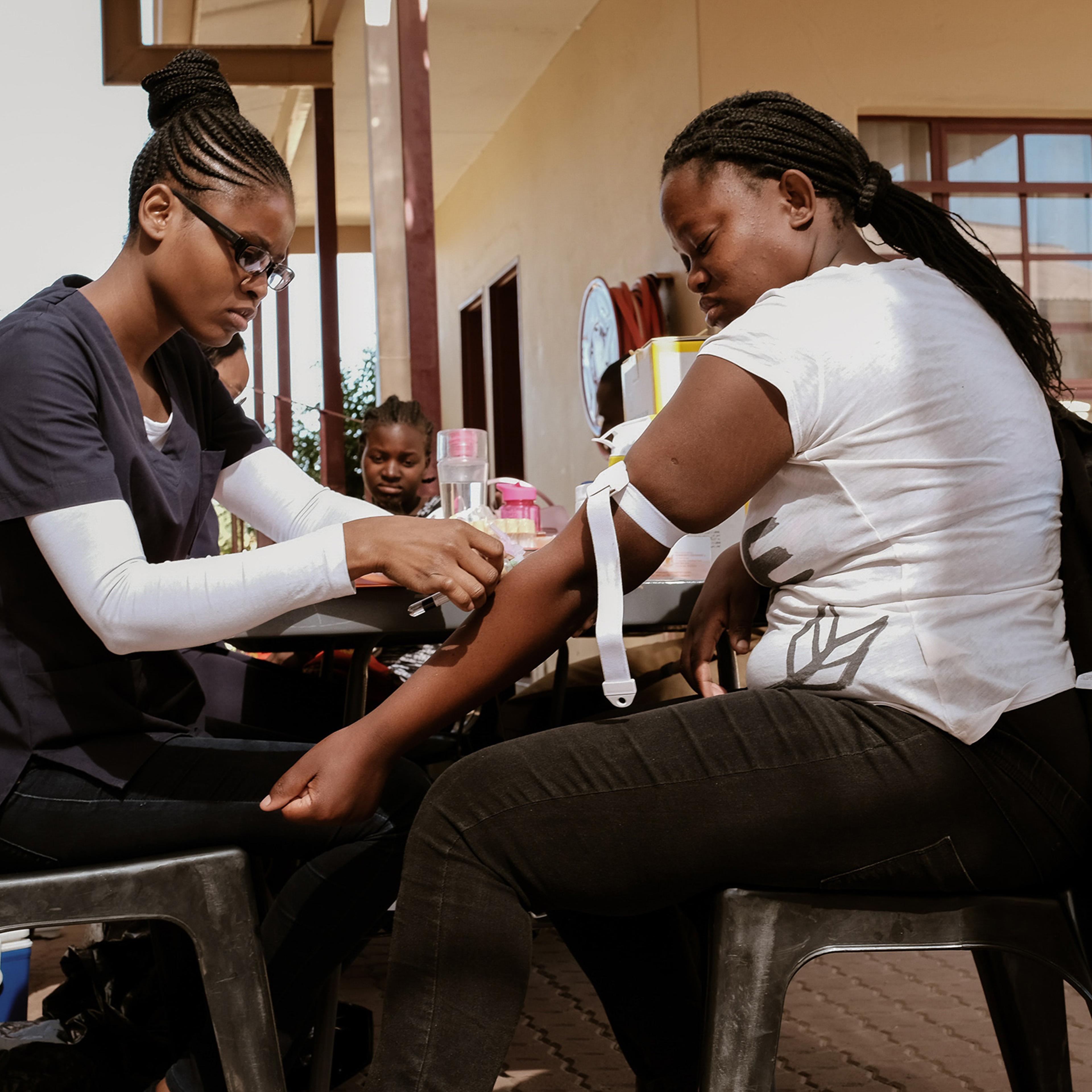 DREAMS program attendee Njandereeko get her blood withdrawn for HIV monitoring. Program attendees are given free medical services of HIV testing, medical assistance, counseling and family planning tools throughout the program.