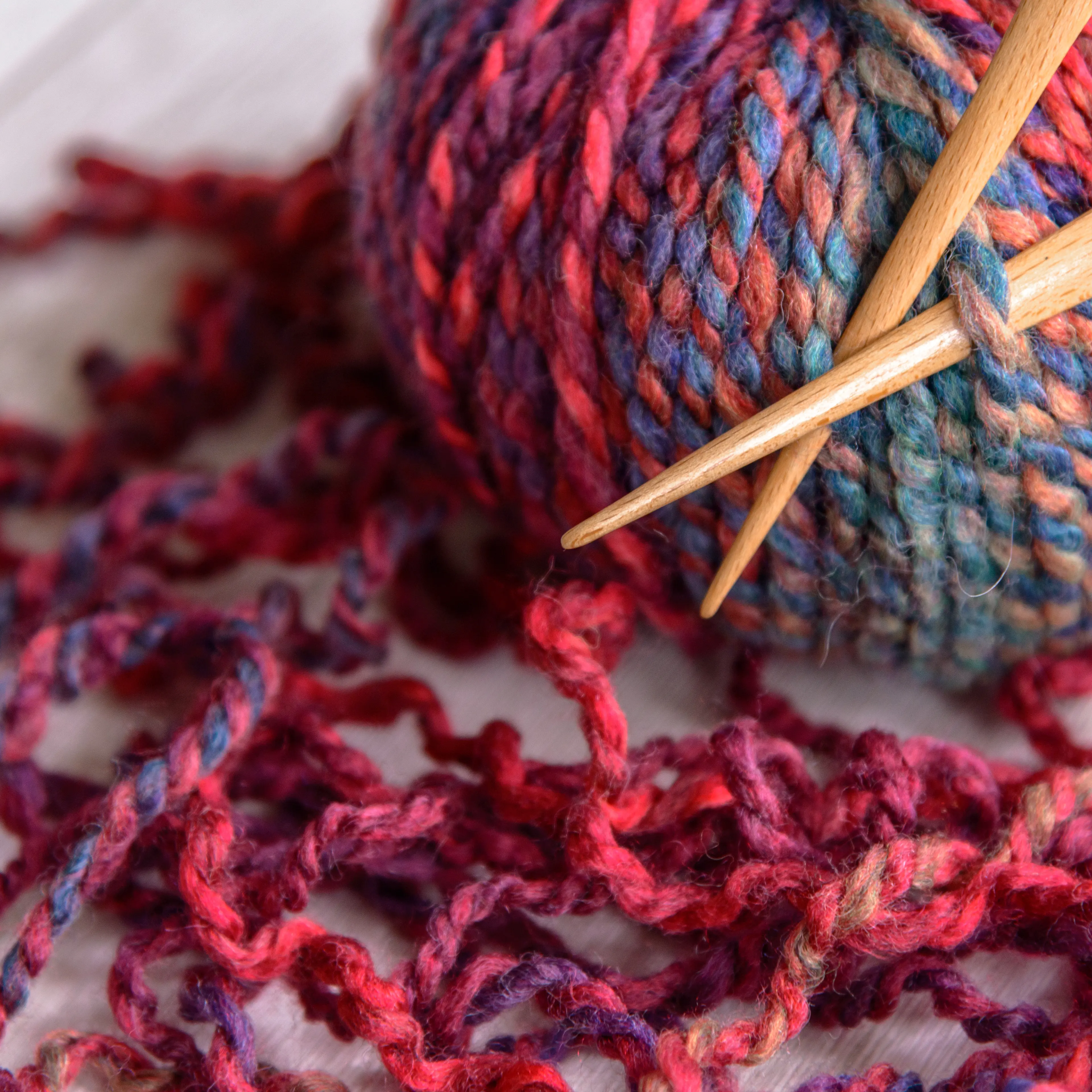 ball of purple yarn and knitting needles