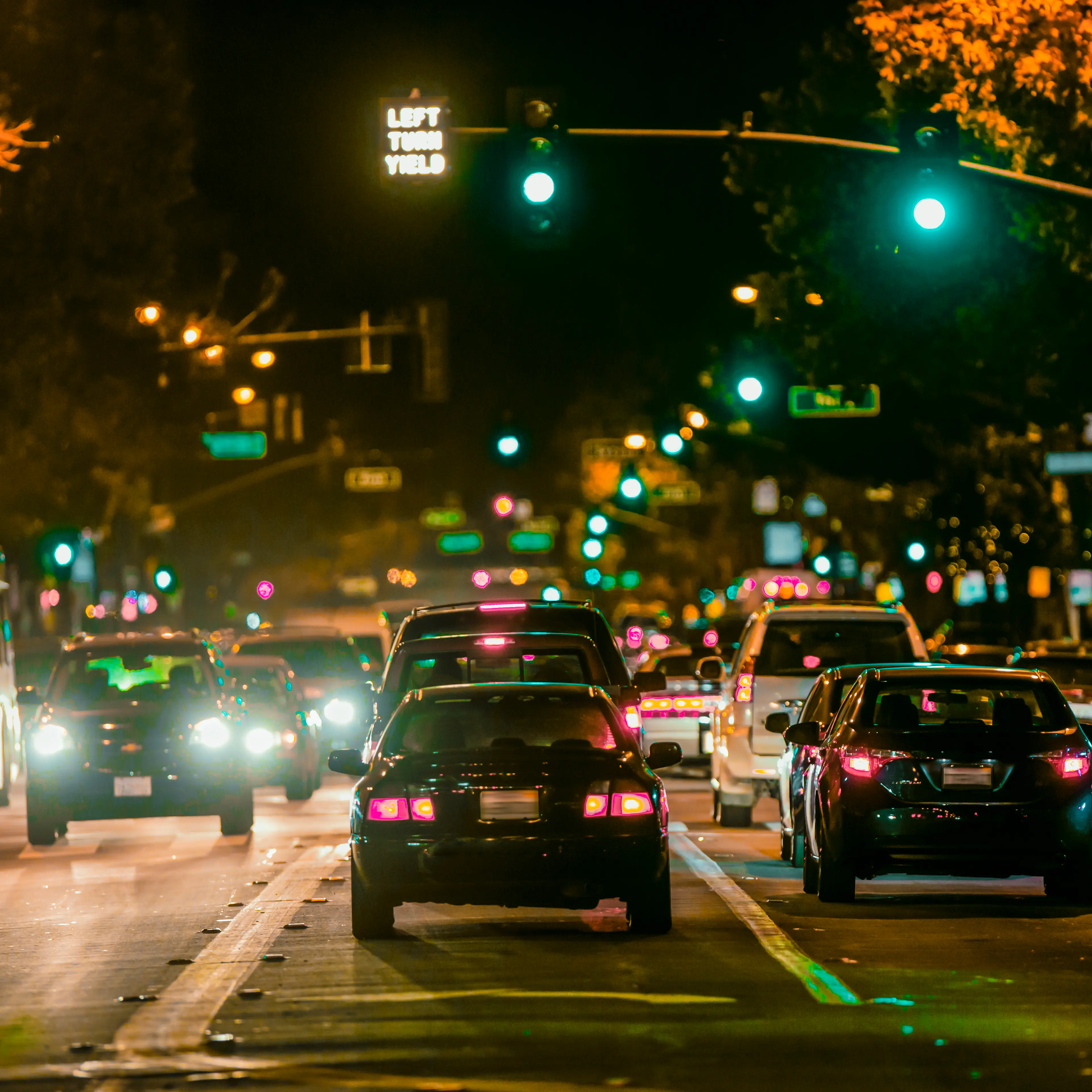 Cars driving in city traffic at night