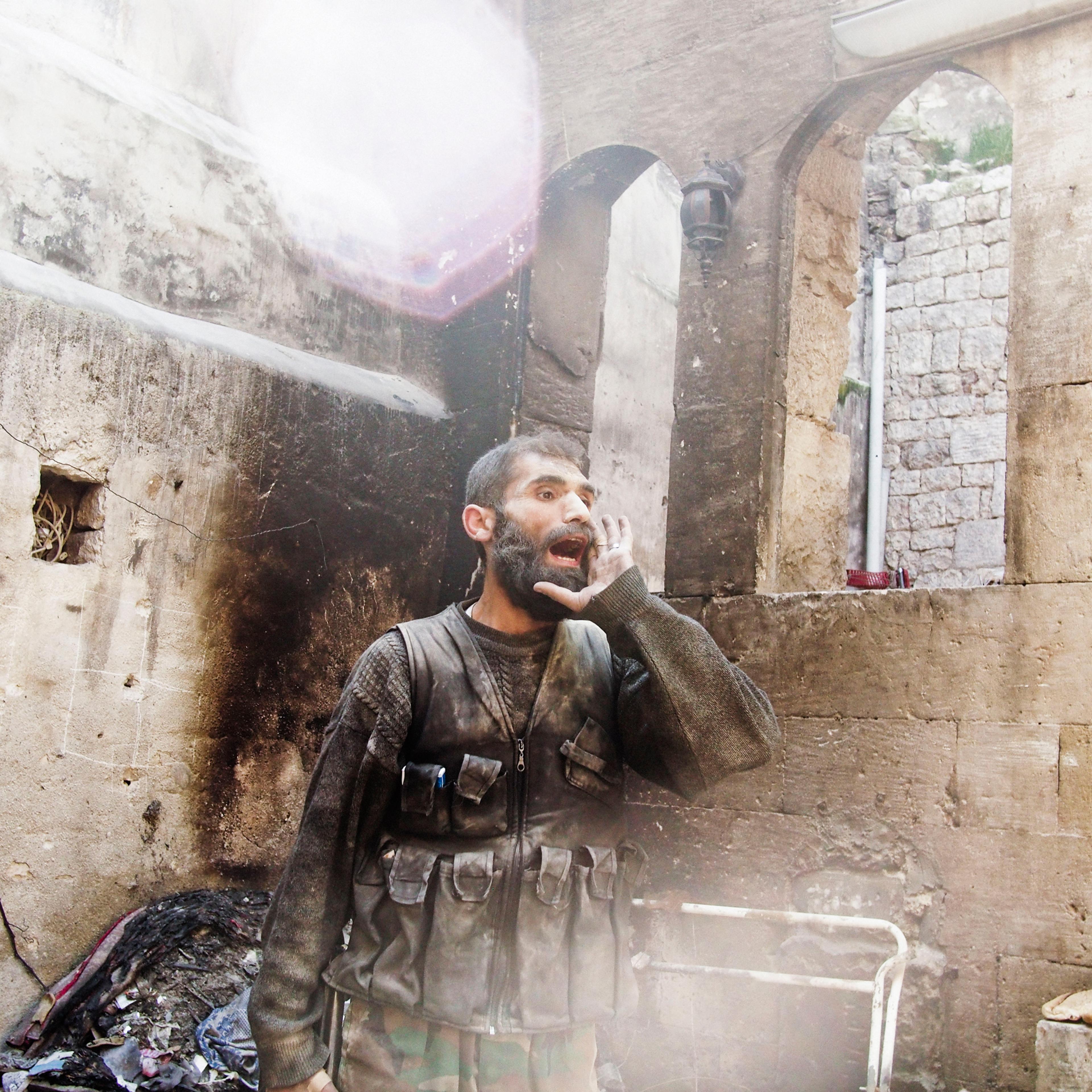 A rebel fighter in Aleppo, Syria yells "Allah u Akhbar" after the sound of an explosion could be heard close-by during fighting in Old City on March 26, 2013.