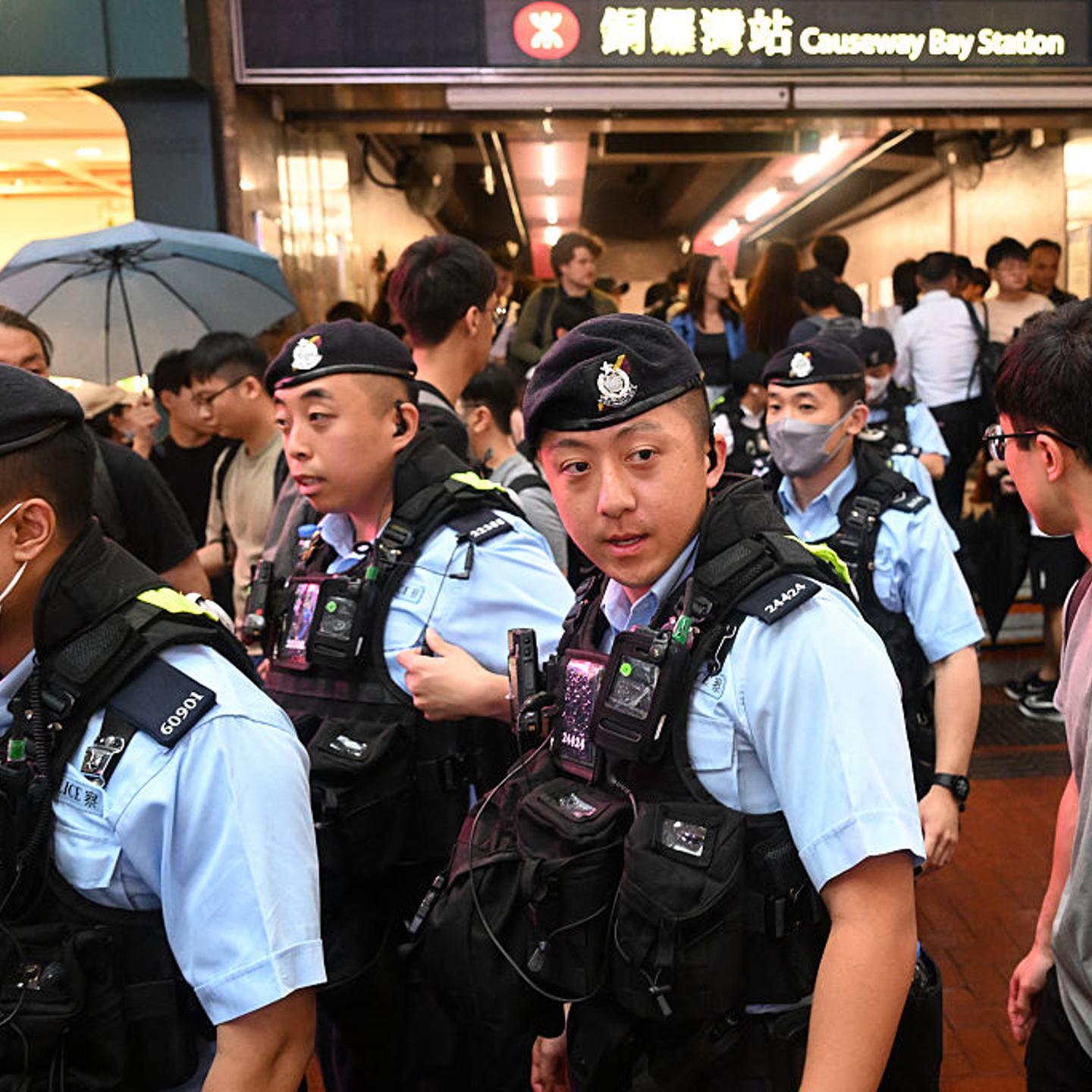 Police gather outside the train station near Victoria Park in Hong Kong's Causeway Bay district on June 4, 2025.