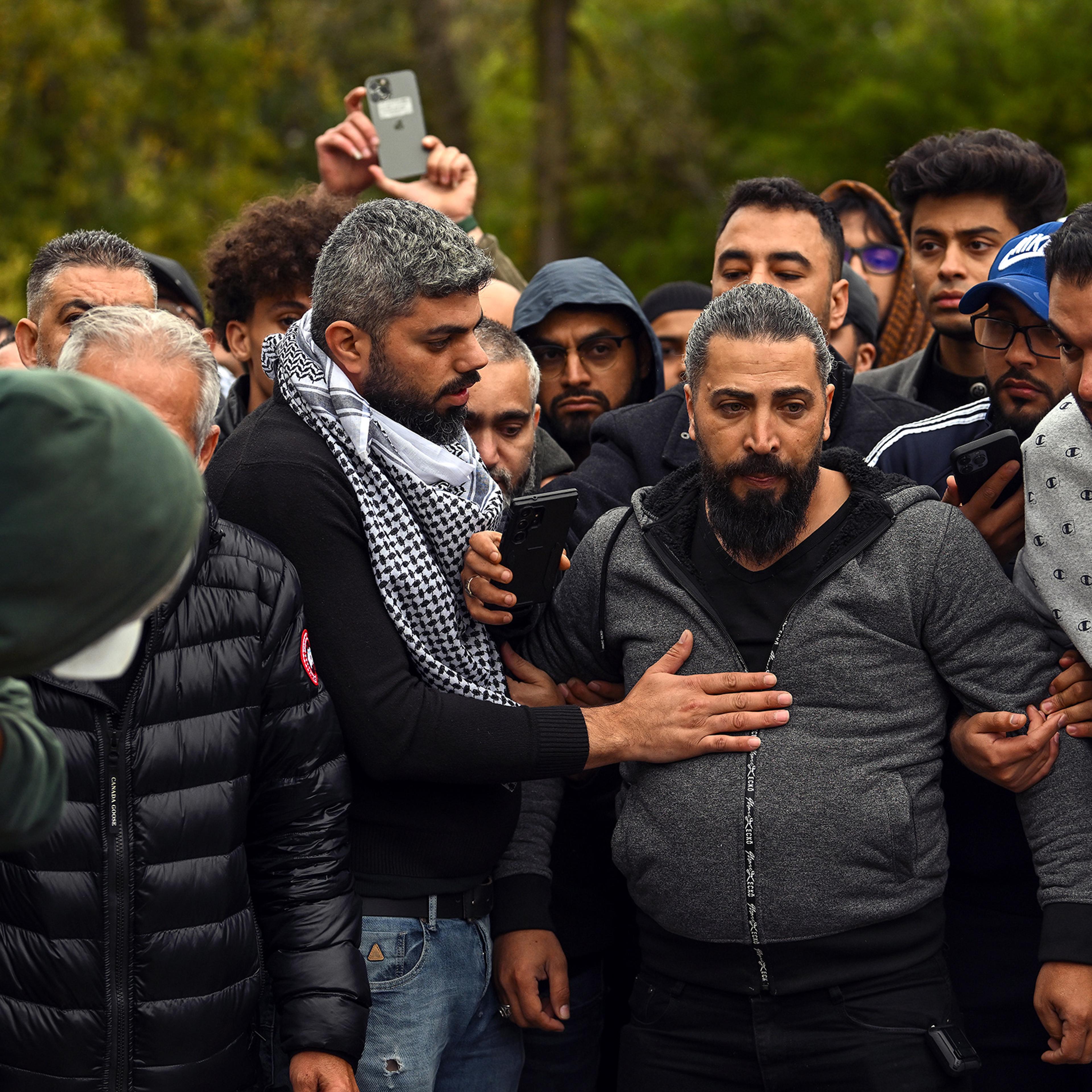 Oday Al-Fayoumi, center in gray hoodie, watches as his 6-year-old Palestinian American Wadea Al-Fayoumi is buried at Parkholm Cemetery on Oct. 16 in LaGrange, Ill.