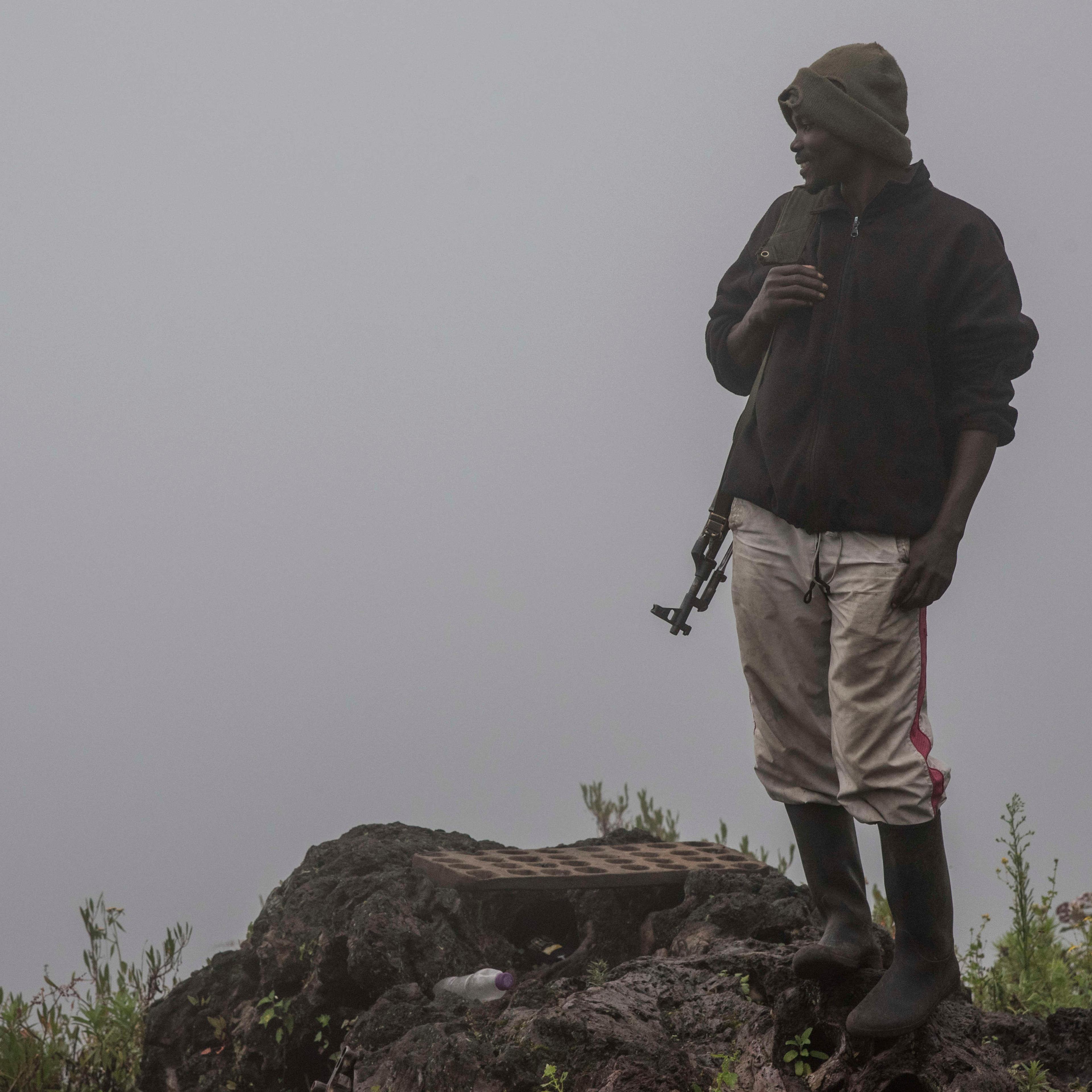 A ranger in the morning mist stands near a security post on