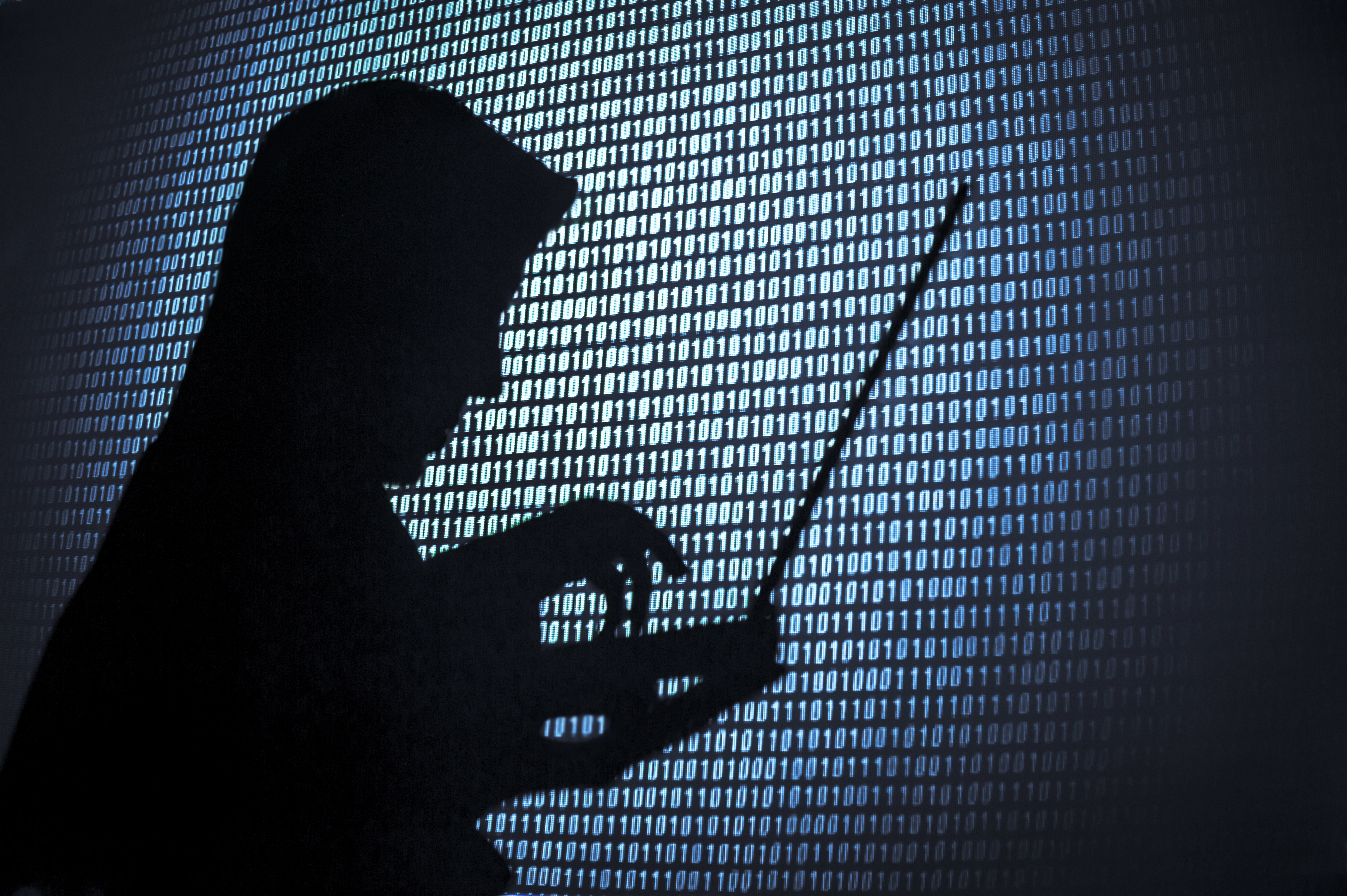 A silhouette of a computer hacker