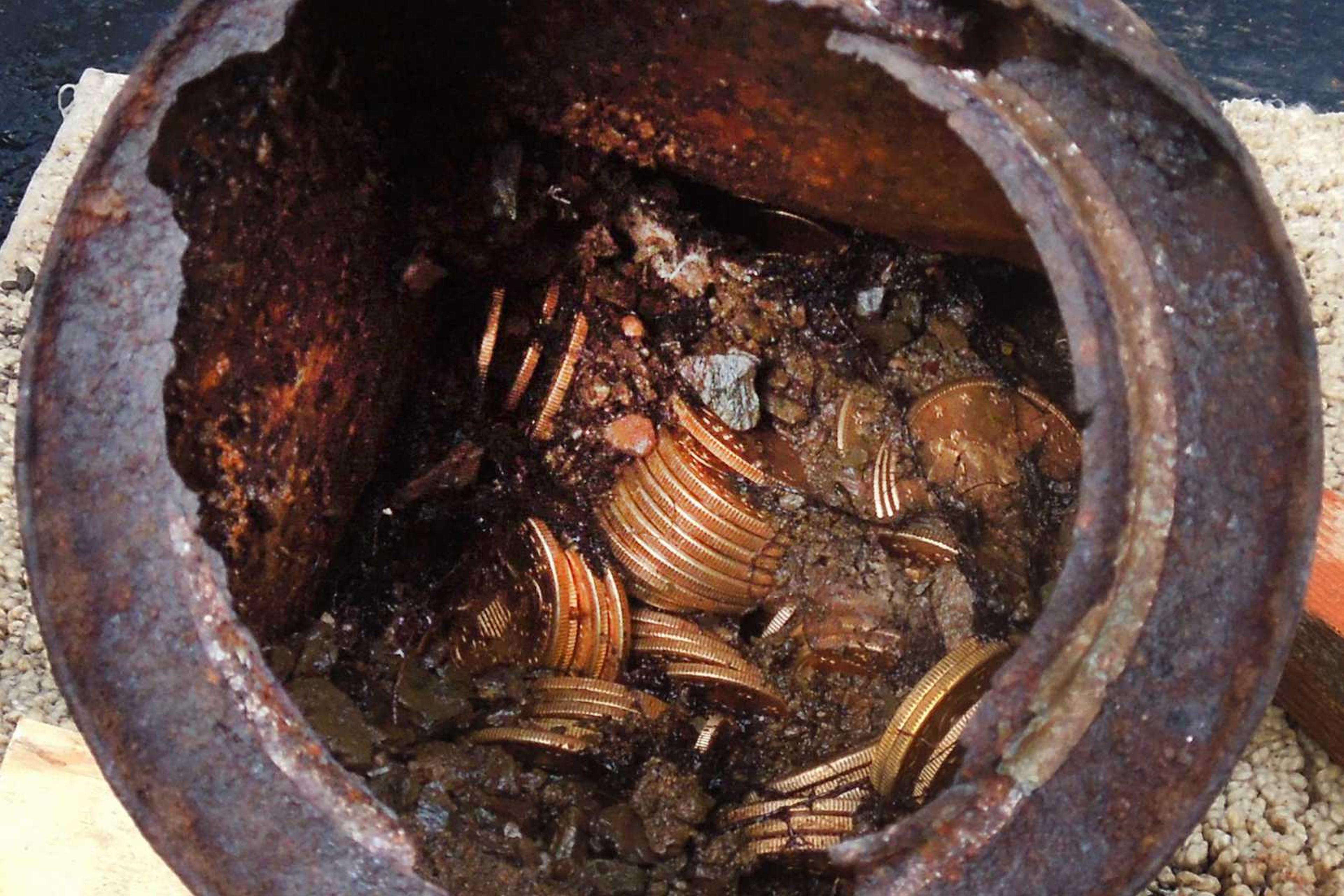 This image provided by the Saddle Ridge Hoard discoverers via Kagin's, Inc., shows one of the six decaying metal canisters filled with 1800s-era U.S. gold coins unearthed in California by two people who want to remain anonymous.