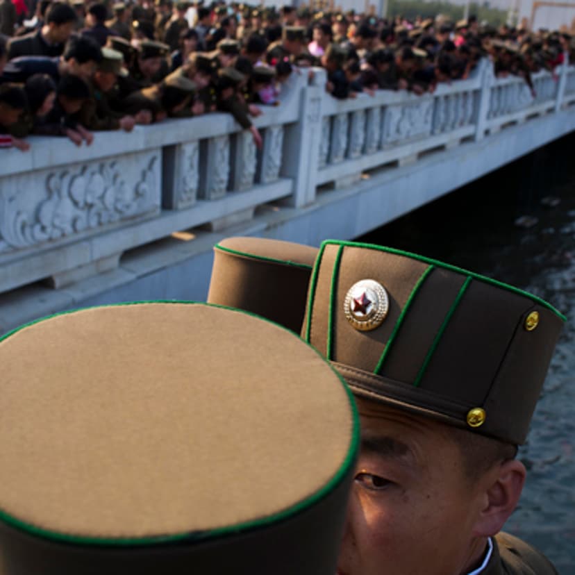 North Korean soldiers and civilians stand on a foot bridge to look at goldfish in a moat as they tour the grounds of Kumsusan Palace of the Sun, the mausoleum where the bodies of the late leaders Kim Il Sung and Kim Jong Il lie embalmed, in Pyongyang on