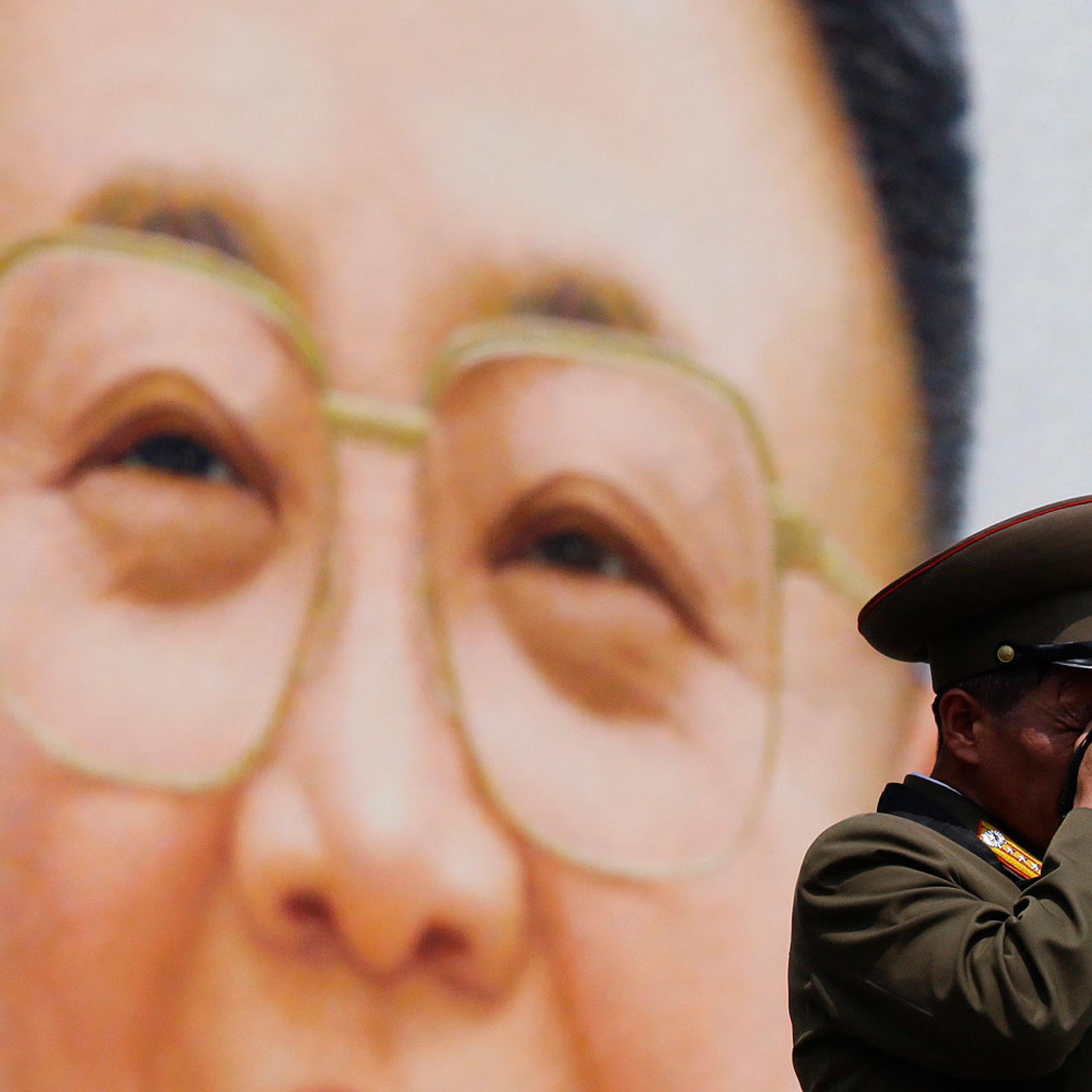 A military officer takes a photograph in front of a giant portrait of late North Korean leader Kim Jong-il during a parade to mark the 60th anniversary of the signing of a truce in the 1950-1953 Korean War at Kim Il-sung Square, in Pyongyang July 27, 2013